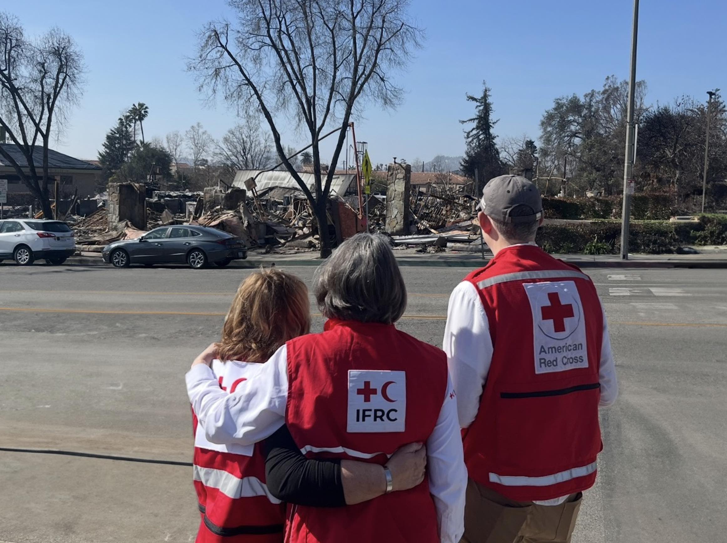 La presidenta de la IFRC, Kate Forbes, junto a personas voluntarias de la Cruz Roja Americana mientras examinan los daños causados por los recientes incendios forestales en Los Ángeles, California.