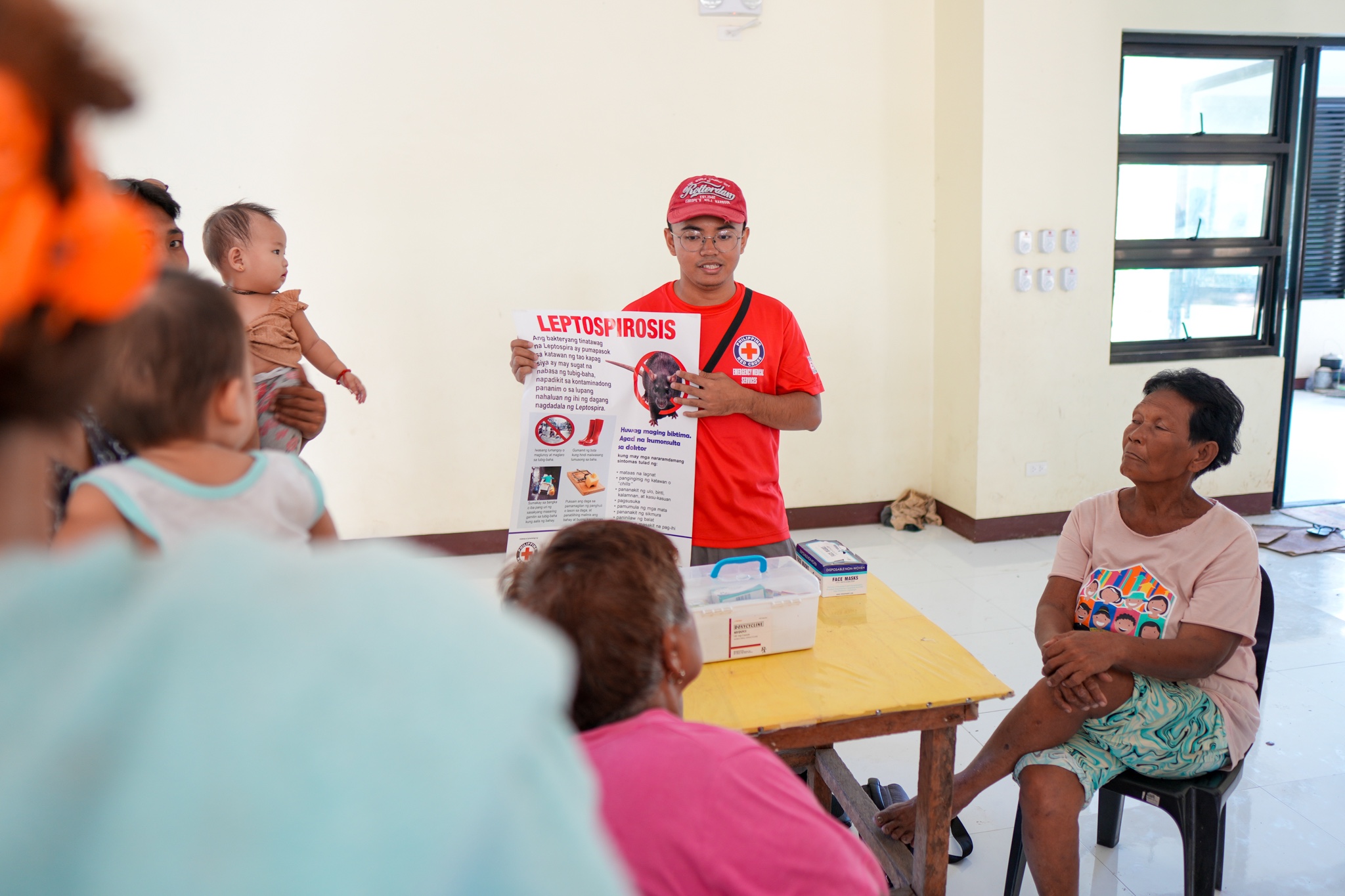 Final-year nursing student and Red Cross volunteer James Asma explains how to stay safe from leptospirosis, a bacterial disease that often affects people and livestock when water supplies are contaminated in the aftermath of the tropical storms or floods.
