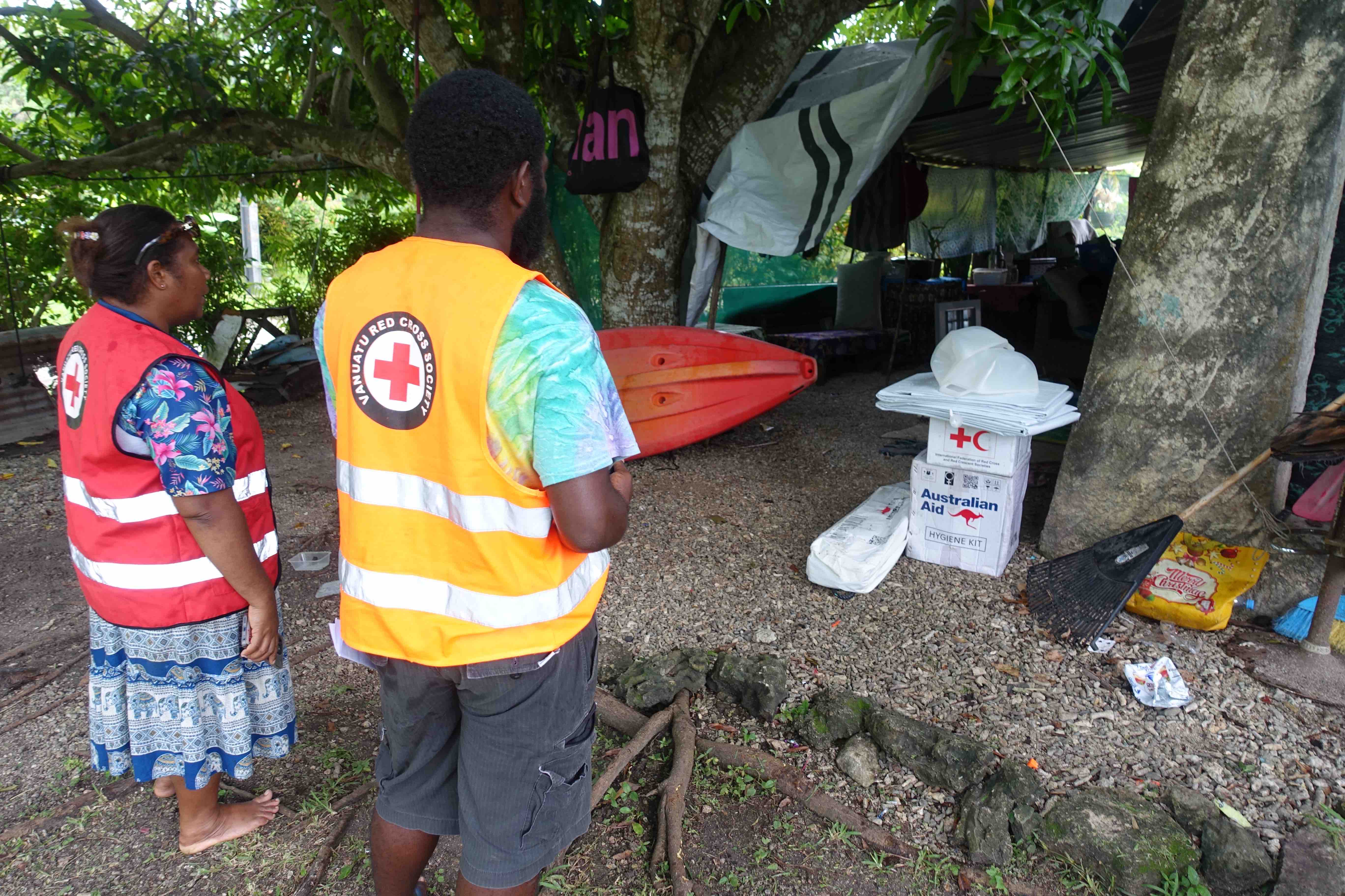 Volunteers with the Vanuatu Red Cross meet with a family that was living in a makeshift tent after the earthquake destroyed their home.