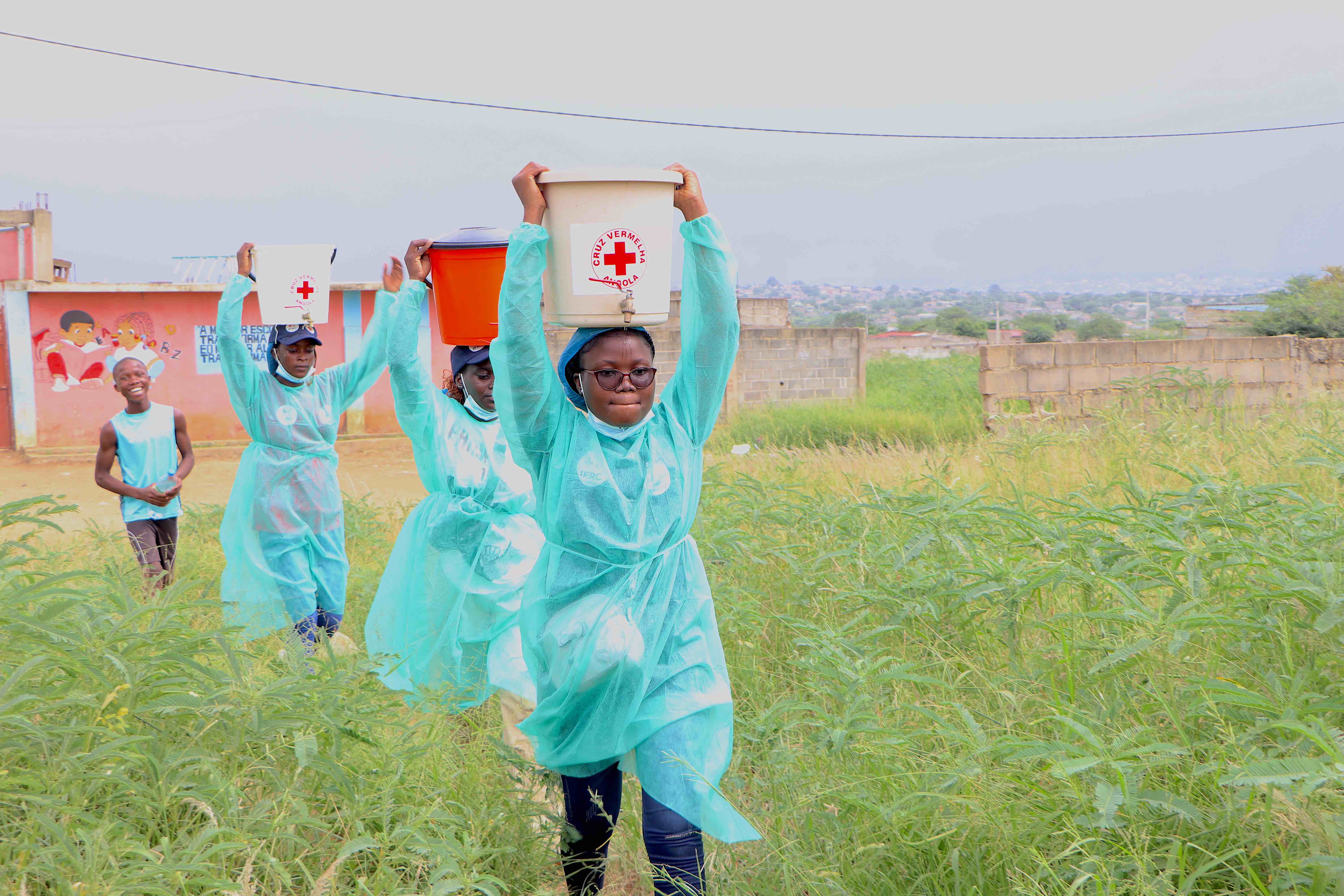 Angola Red Cross volunteers carry treated water in buckets balanced on their heads in Caucuaco, in the western coastal province of Luanda. 