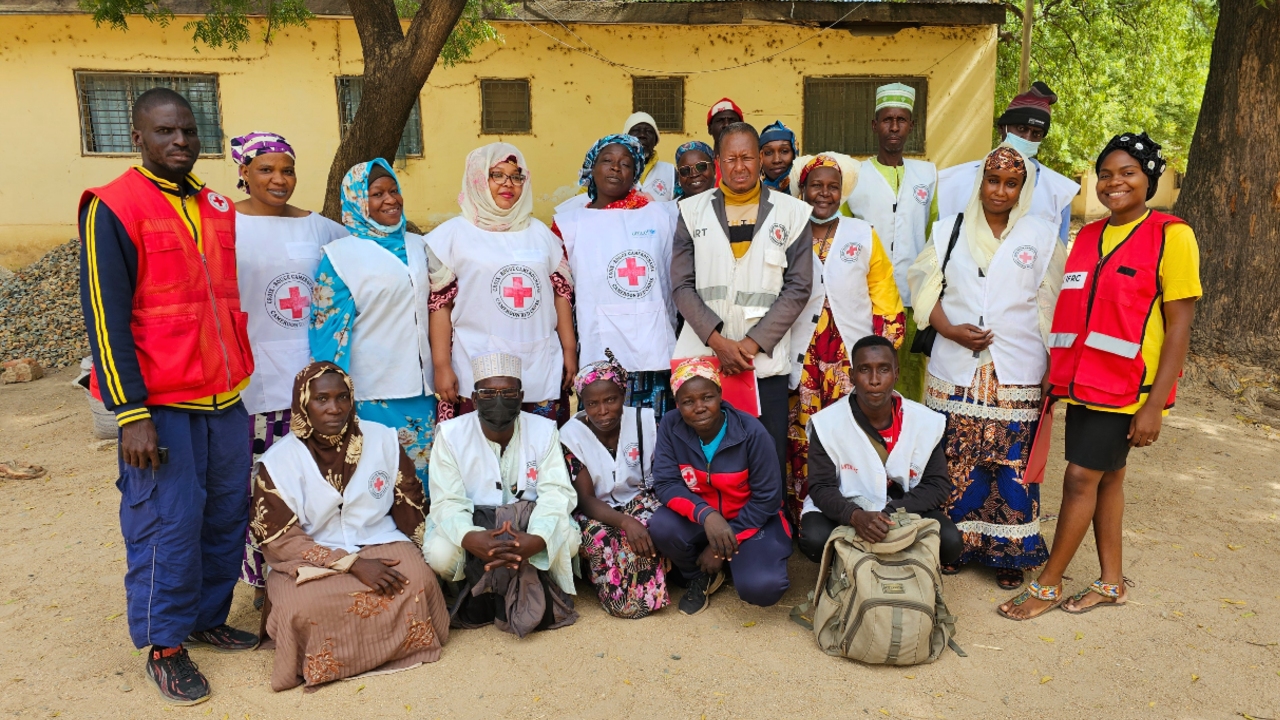 Rouyatou and Ali from Cameroon Red Cross stand proudly alongside fellow Cameroon Red Cross volunteers and staff in Maroua.