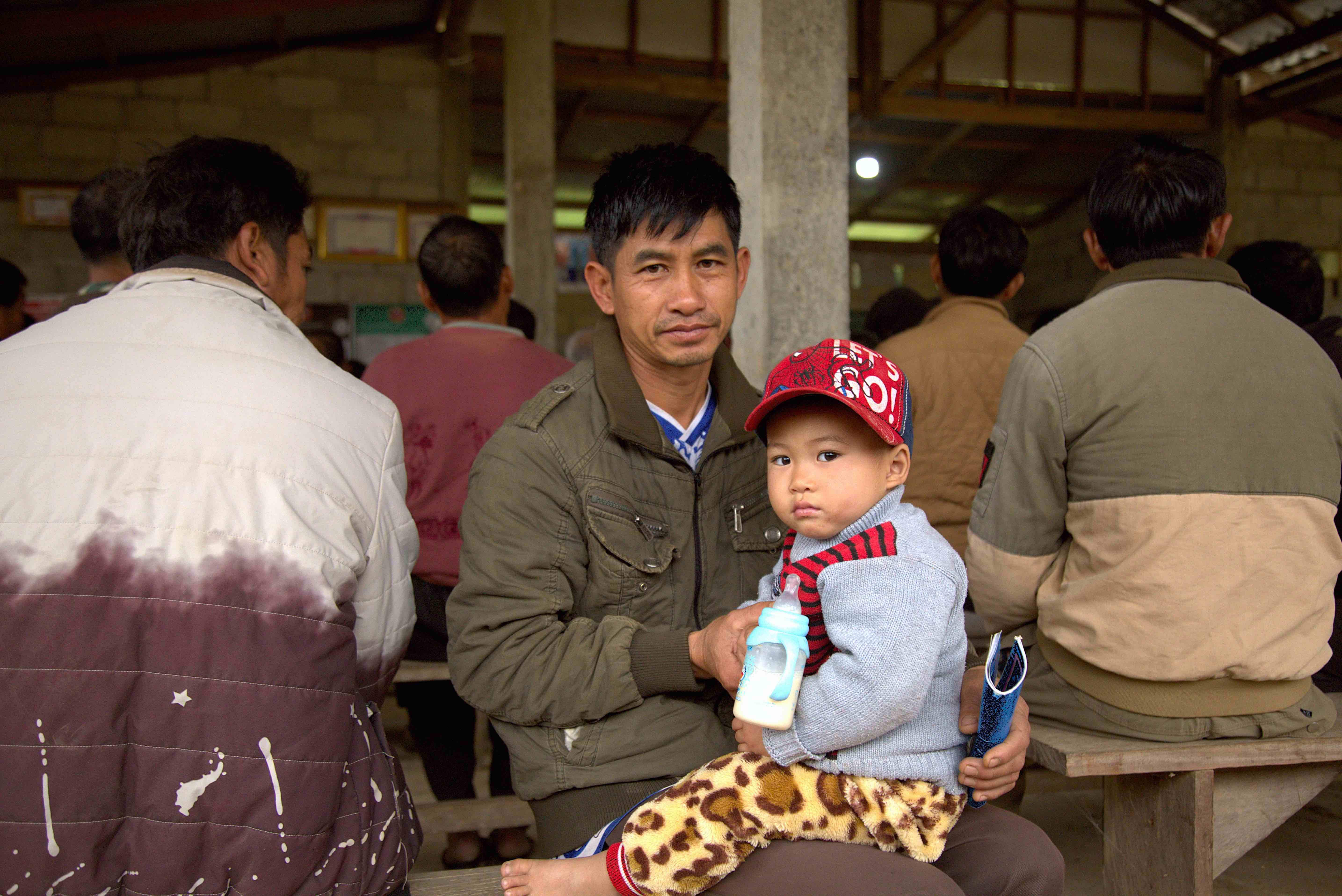 Keokaen and his son Bounkhorp waiting for cash assistance supported by Lao Red Cross and IFRC. 