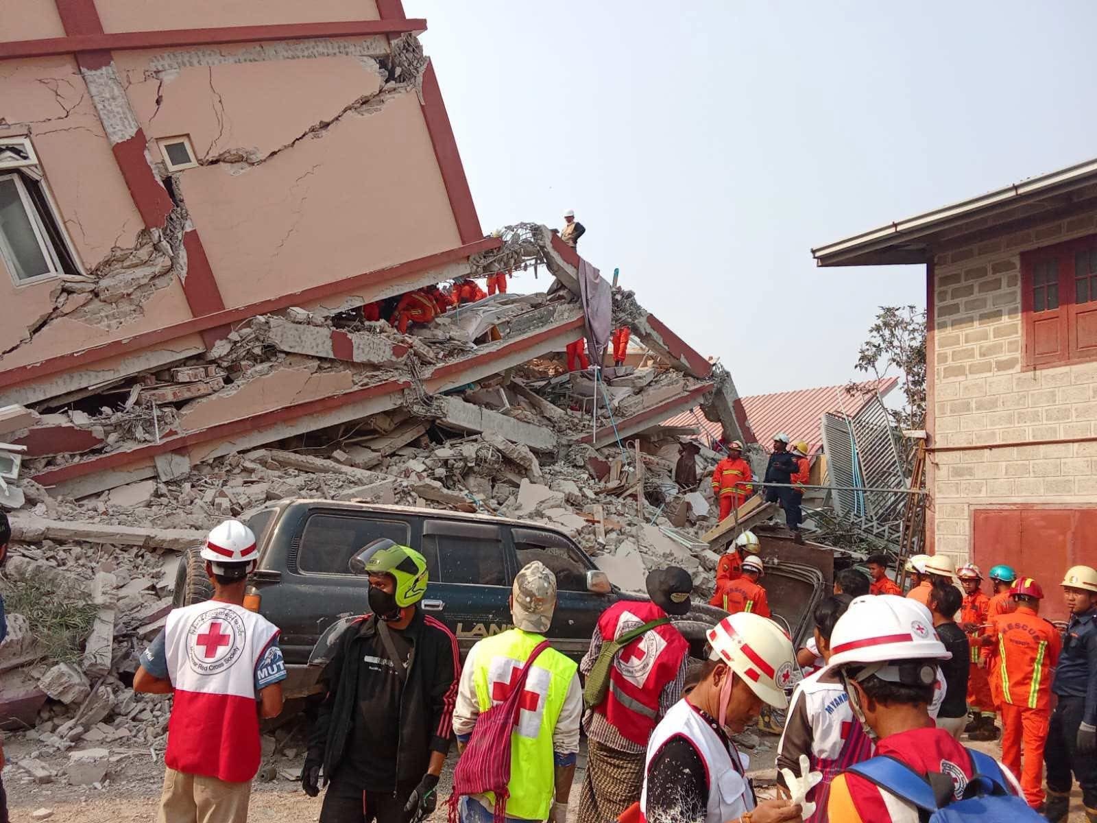 Rescue teams from the Myanmar Red Cross look for survivors in a collapsed building following a 7.7 magnitude earthquake in central Myanmar on 28 March 2025.