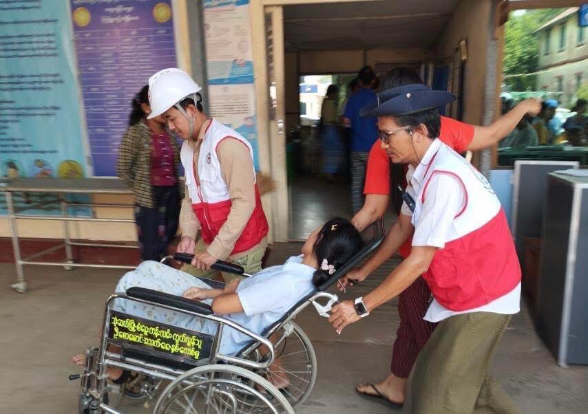 Myanmar Red Cross personnel transport earthquake survivor to medical facility for urgent care.