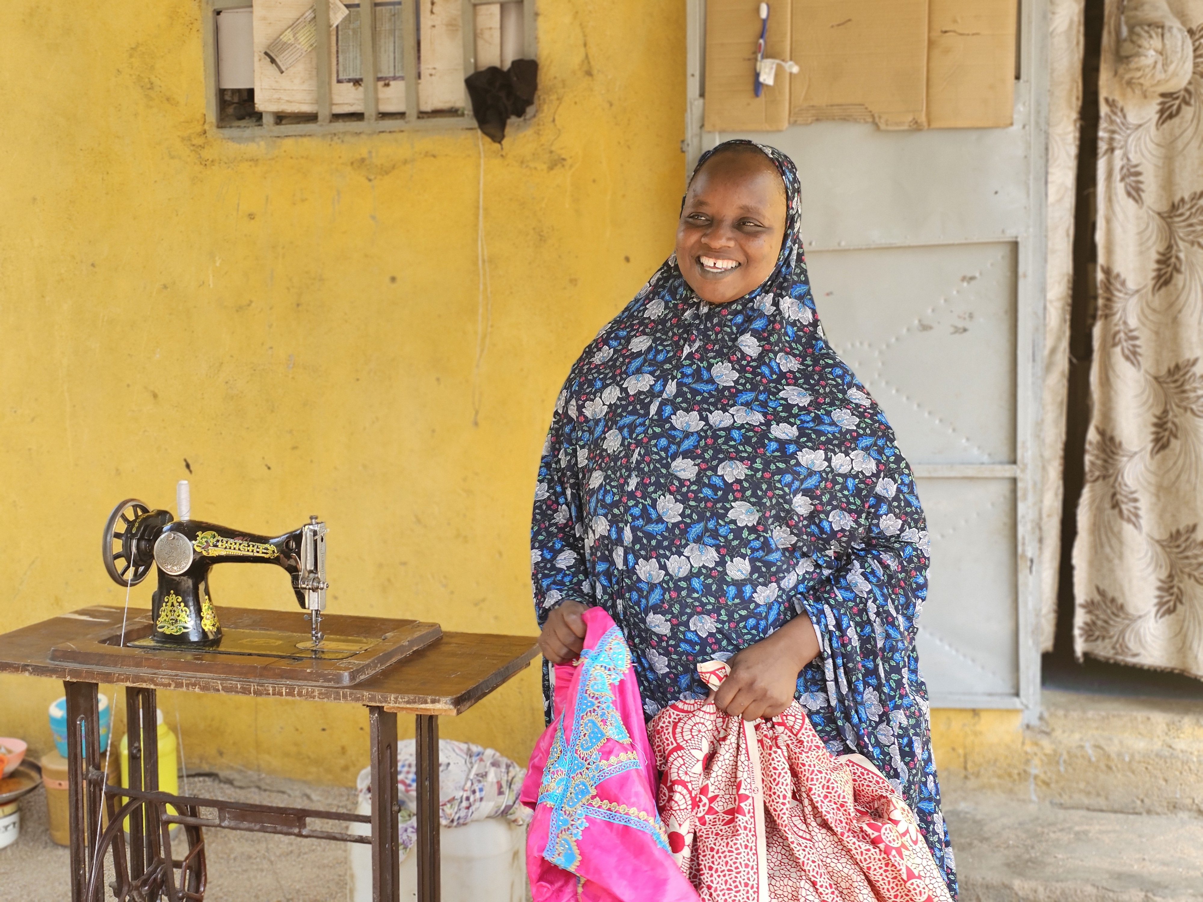 Standing in front of her house, Souraya explains to Cameroon Red Cross volunteers how the Kodek Mothers' Club has changed her life.
