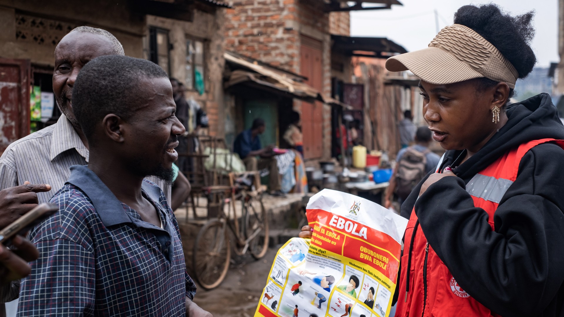 Uganda Red Cross Society volunteer, Gloria, speaks to people in Bwaise, Kampala about how to spot signs of Ebola, what to do if they notice symptoms, and how they can keep themselves safe.