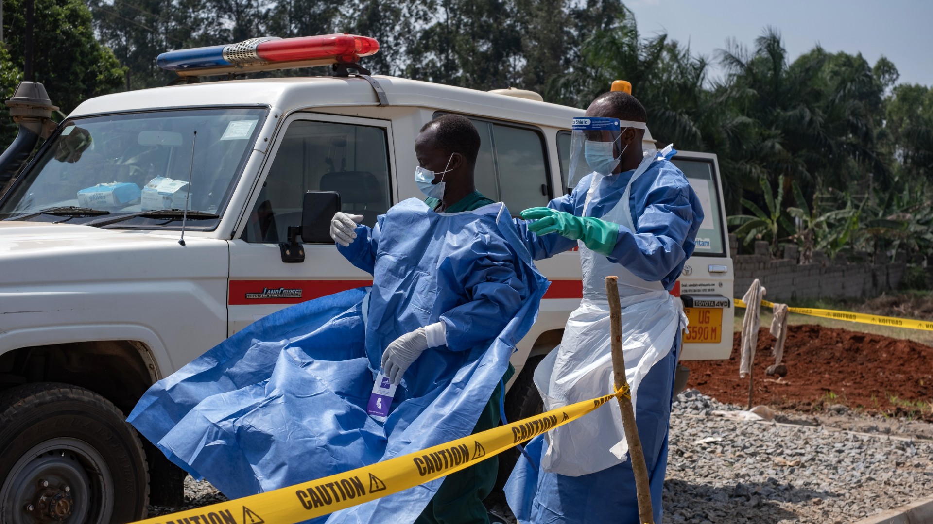 Ali and Alex, experienced ambulance attendants with the Uganda Red Cross Society, put on personal protective equipment and sanitise their vehicle before heading out to pick up suspected Ebola patients in the community and transport them to hospital.