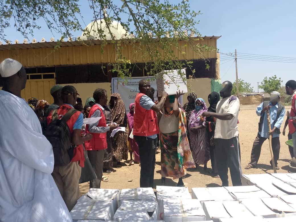 In Sennar State, Sudanese Red Crescent volunteers distribute food baskets for people displaced by fighting. The food packages were provided in cooperation with the Qatar Red Crescent.