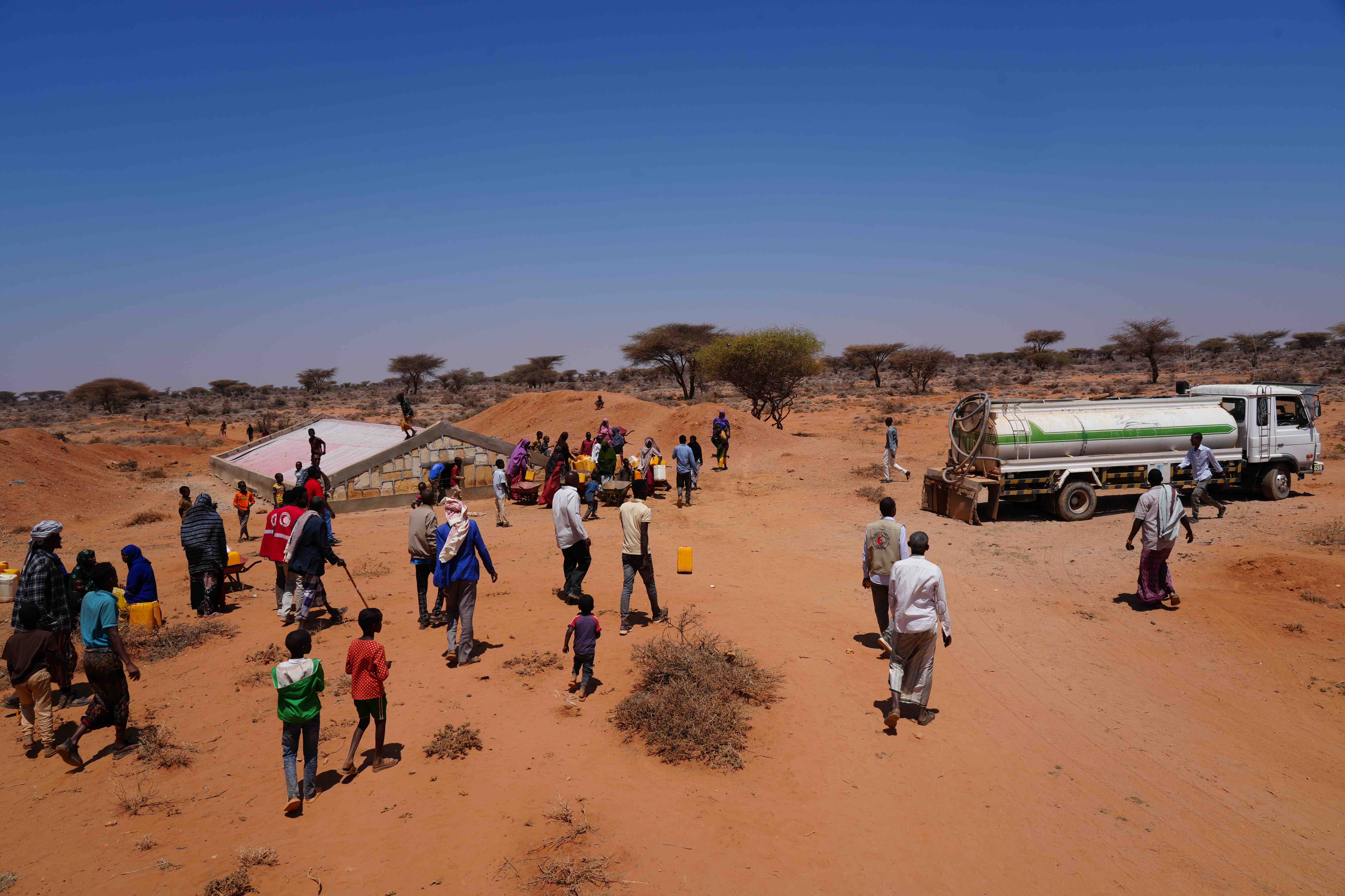 A water truck arrives at the Geed Abokor IDP camp to refill the berked (traditional water reservoir) with fresh water. The community, displaced by the impacts of climate change, pools household contributions to fund this weekly necessity, as there are no other viable water sources nearby. 