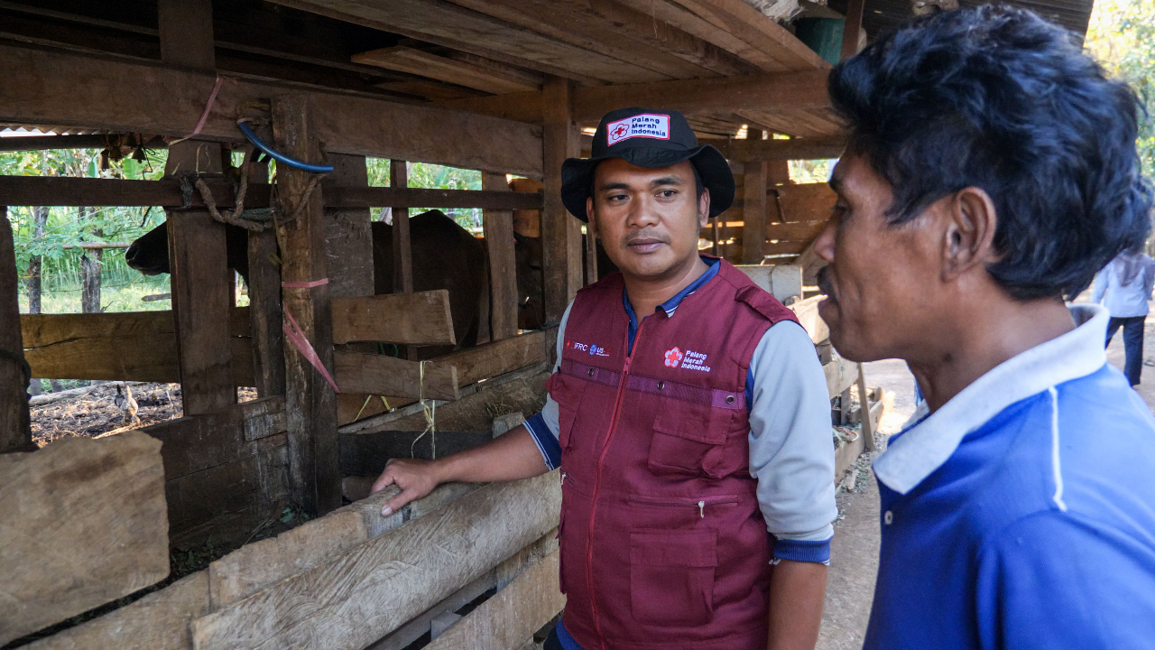 CP3 volunteer and Tallasa Baru village head, Irwan, speaks to a community member about how to identify different animal health risks and how he can protect his cattle and other animals from getting sick.