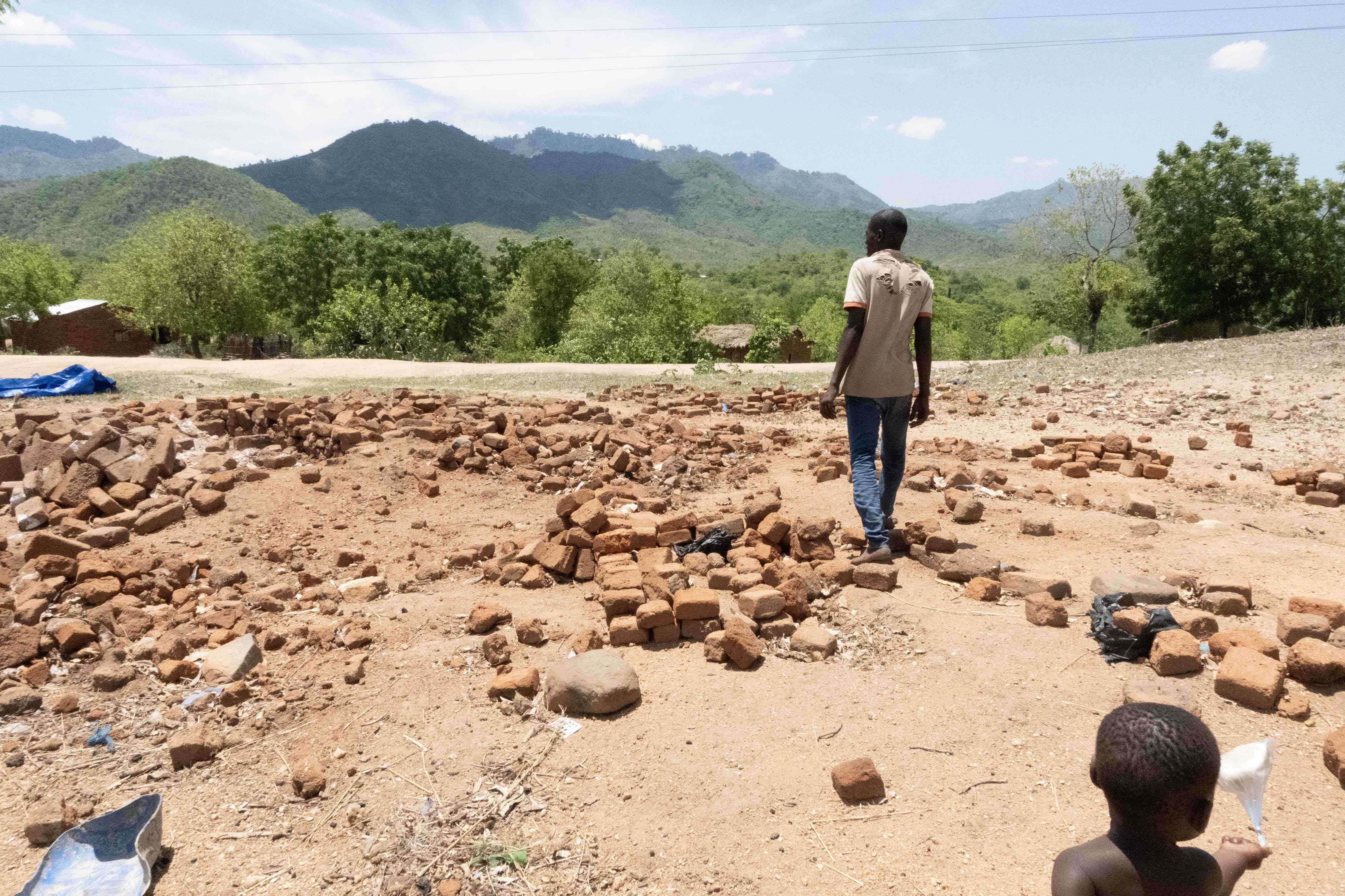A man in the Malawian village of Chiwalo in southern Malawi, inspects the place where his home and fields were washed away by floods from Cyclone Freddy in March 2023.