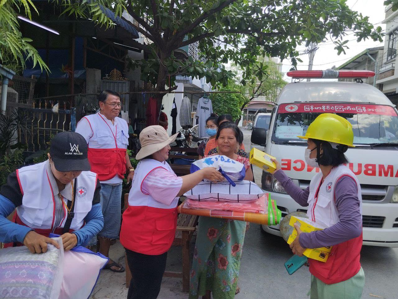Honey Thin (au centre, coiffée d'une casquette beige), enseignante et volontaire de la Croix-Rouge du Myanmar, distribue des produits de première nécessité aux habitants touchés par le récent tremblement de terre au Myanmar.