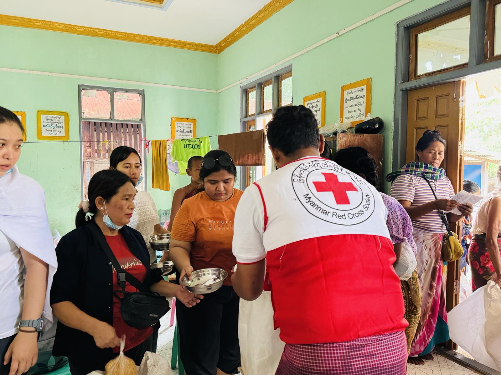 La profesora y voluntaria Honey Thin (en el centro con camiseta naranja) participa activamente en la respuesta de la Cruz Roja de Myanmar al reciente terremoto.