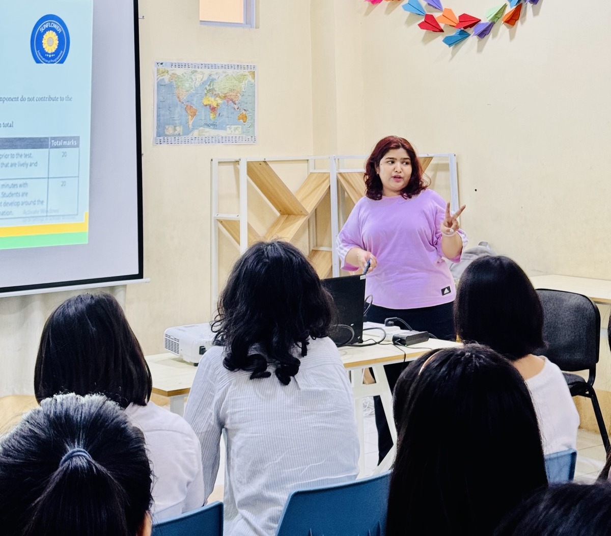 La profesora Honey Thin imparte una clase de inglés en la Sunflower Myanmar International School, haciendo participar a sus estudiantes en el aprendizaje en el aula. Esta foto fue tomada antes del terremoto que dañó la escuela.