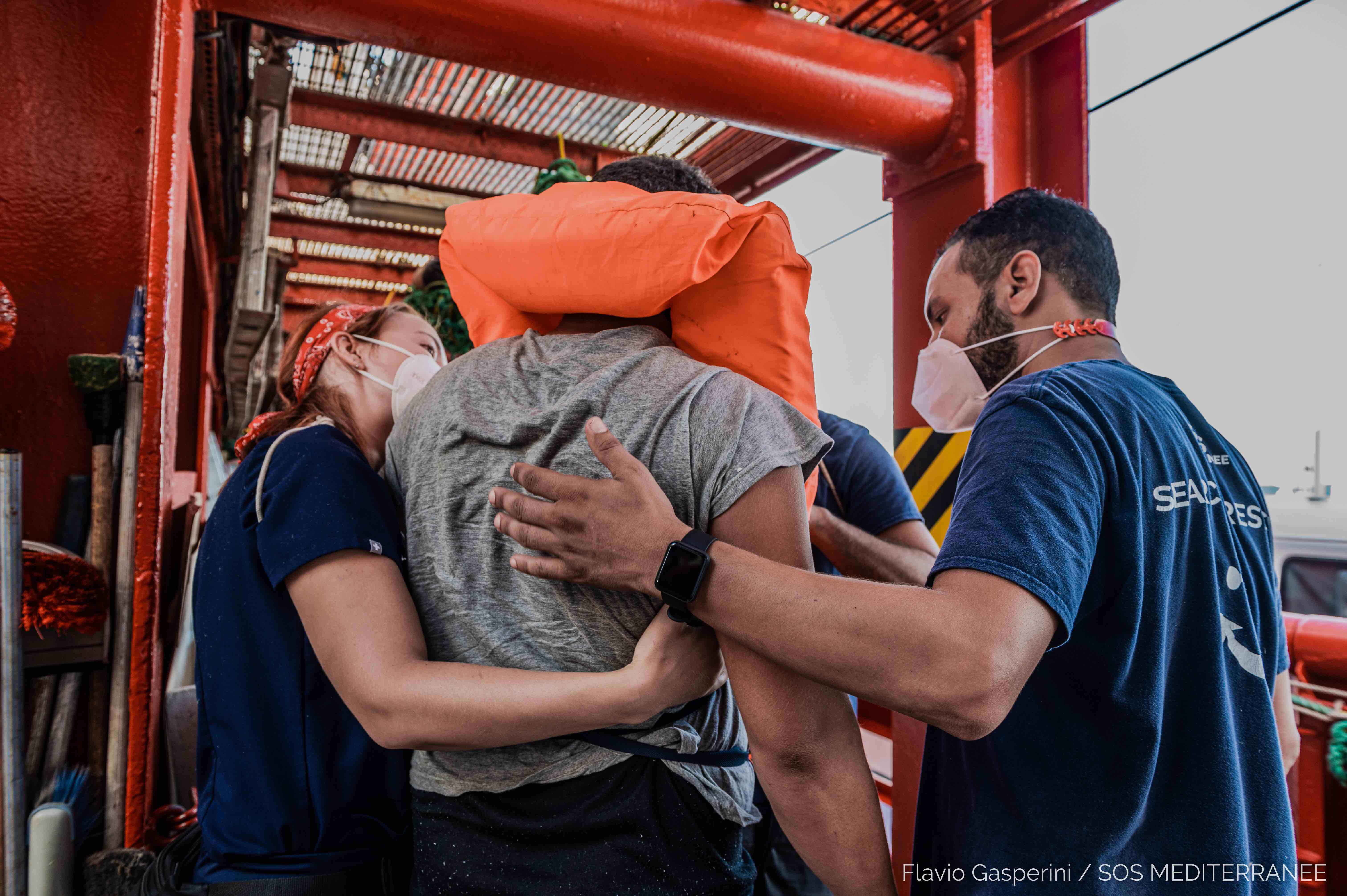 Les équipes de secours de l'IFRC et de SOS Meditarranee aident un homme qui vient d'être ramené à bord du navire de sauvetage Ocean Viking en Méditerranée centrale.