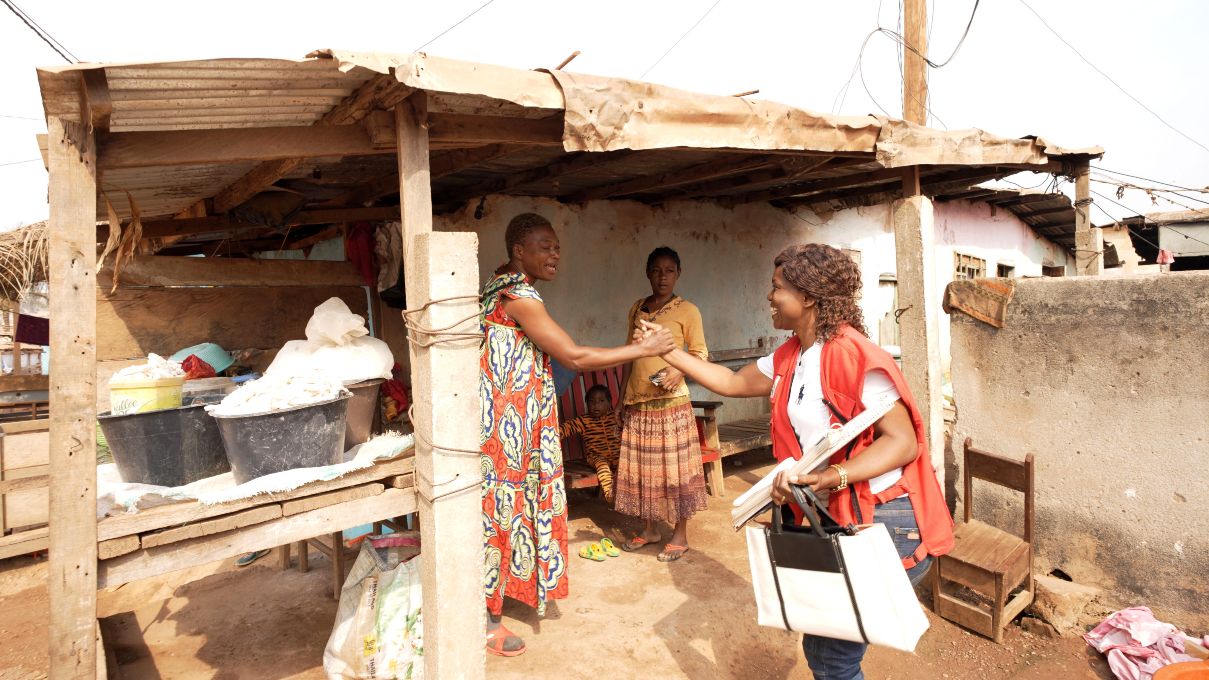 Rachel Bami (right) from the Cameroon Red Cross Society shakes hands with a woman called Amina from Bamvele village. Rachel helped Amina recover from a bout of acute watery diarrhoea (AWD) by teaching her daughter how to prepare Oral Rehydration Solution for her
