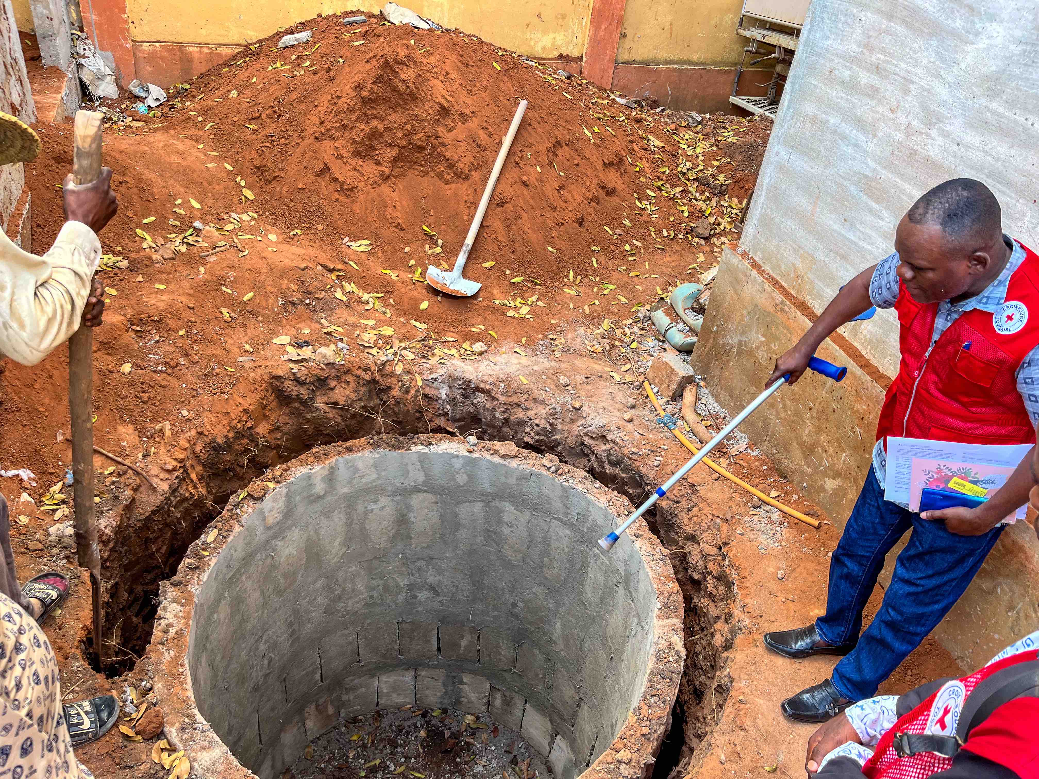 A Togolese Red Cross team inspects a newly constructed holding tank that will be used in a new water and sanitation facility built in a rural community in the western African nation of Togo.