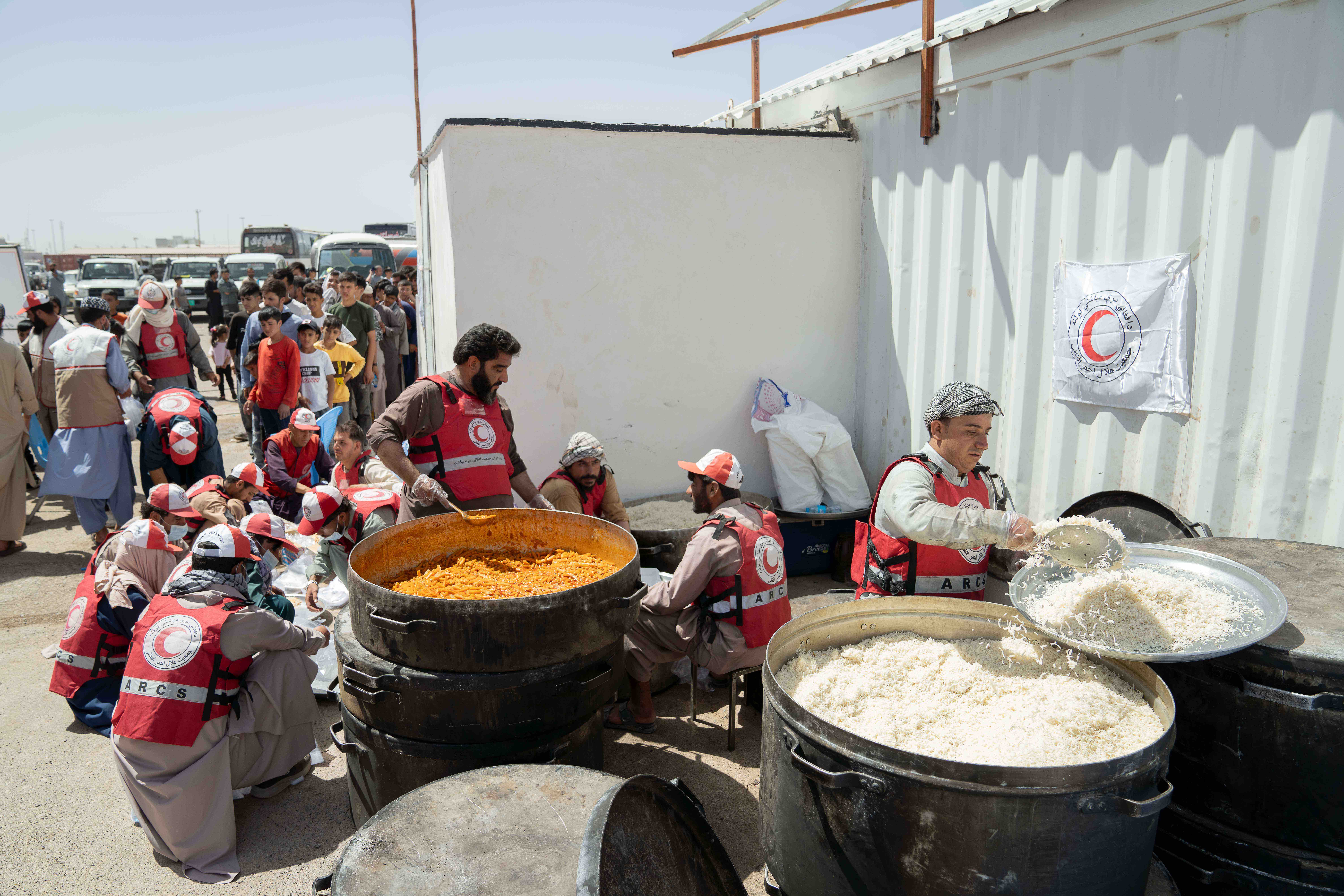 Voluntarios de la Media Luna Roja Afgana preparan comidas para las personas en el paso fronterizo de Islam Qala, en el oeste de Afganistán, por donde han regresado más de 800.000 personas de Afganistán desde Irán desde enero de 2025.