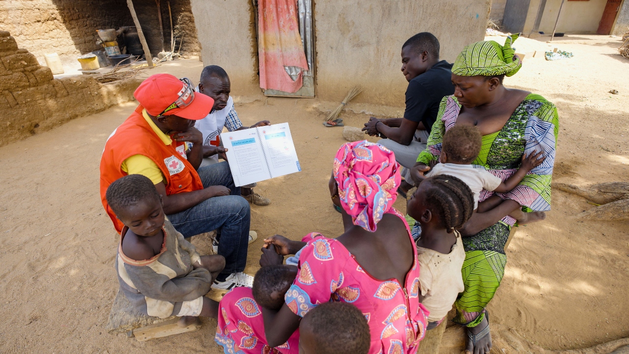 Cameroon Red Cross volunteers use the IFRC’s Epidemic Control Toolkit to teach families about measles signs and preventive measures.