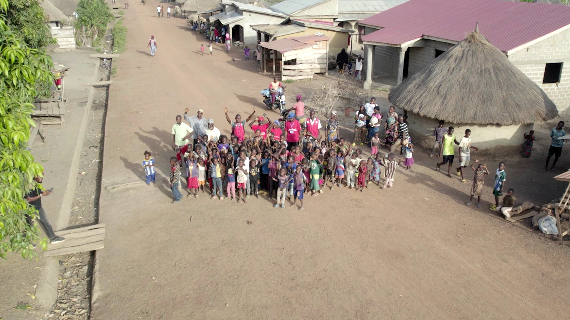 The community in Dalafilani village, Guinea, celebrates together following the construction of a new canal system to reduce disaster and disease risks.
