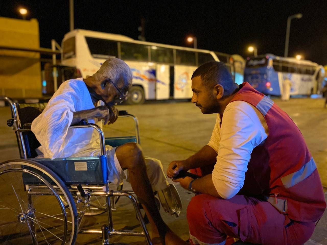 Un voluntario de la Media Luna Roja Egipcia habla con un anciano que acaba de llegar a Qustul, en el sur de Egipto, tras huir de los combates que se prolongan en Sudán desde abril de 2023.