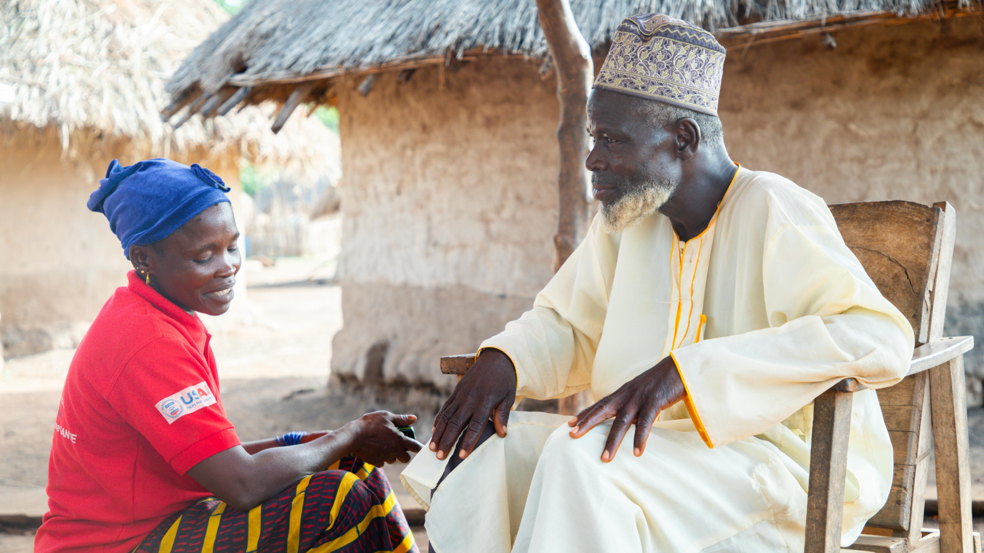 A Guinea Red Cross volunteer speaks to Chief of Dalafinali village, Fodé Oularé, about how flooding is affecting his community.