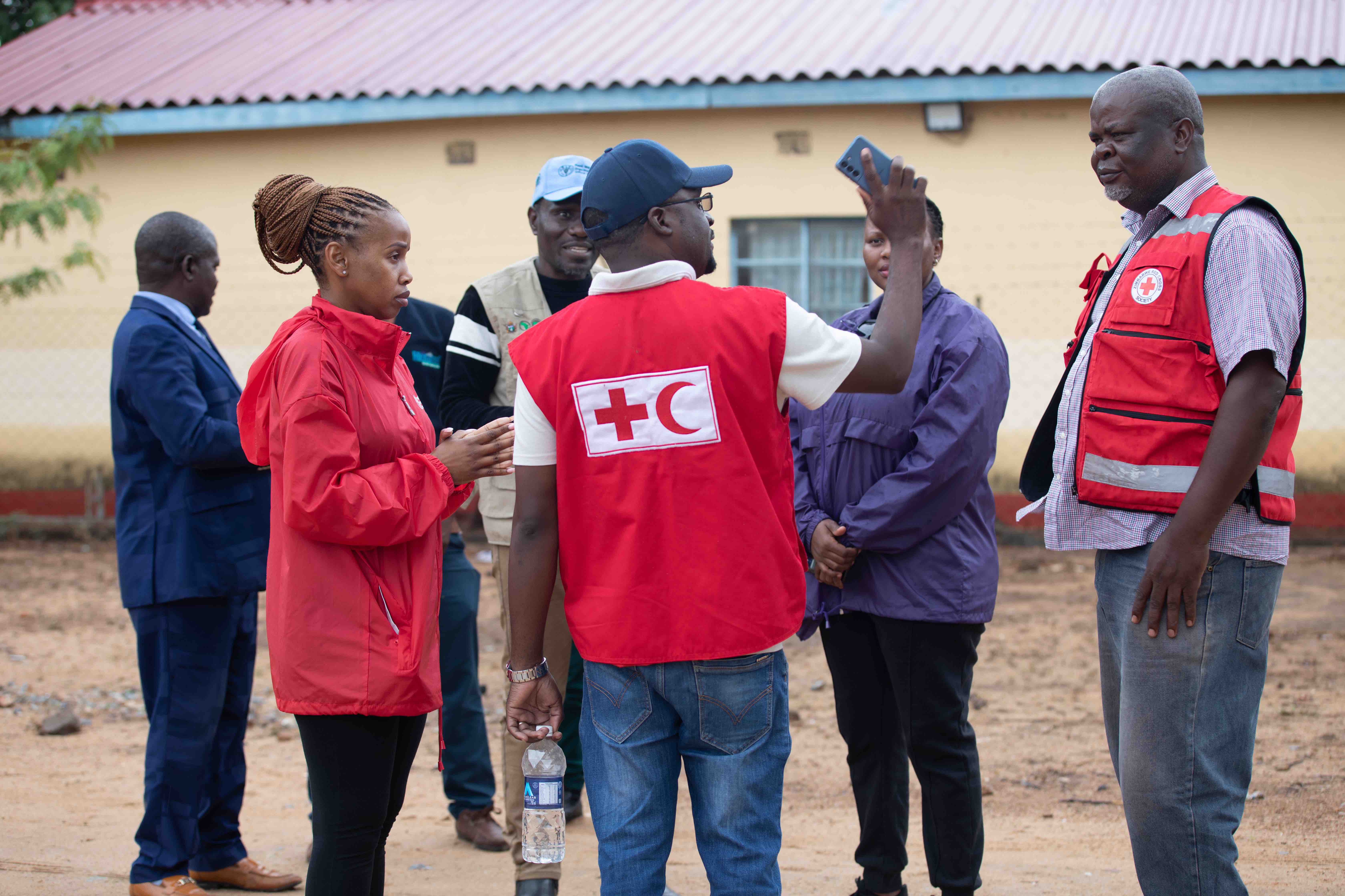 A team from the IFRC and the Zimbabwe Red Cross meet with partners and local leaders in the village of Chibuwe as they prepare for a flood simulation exercise to strengthen community disaster preparedness.  