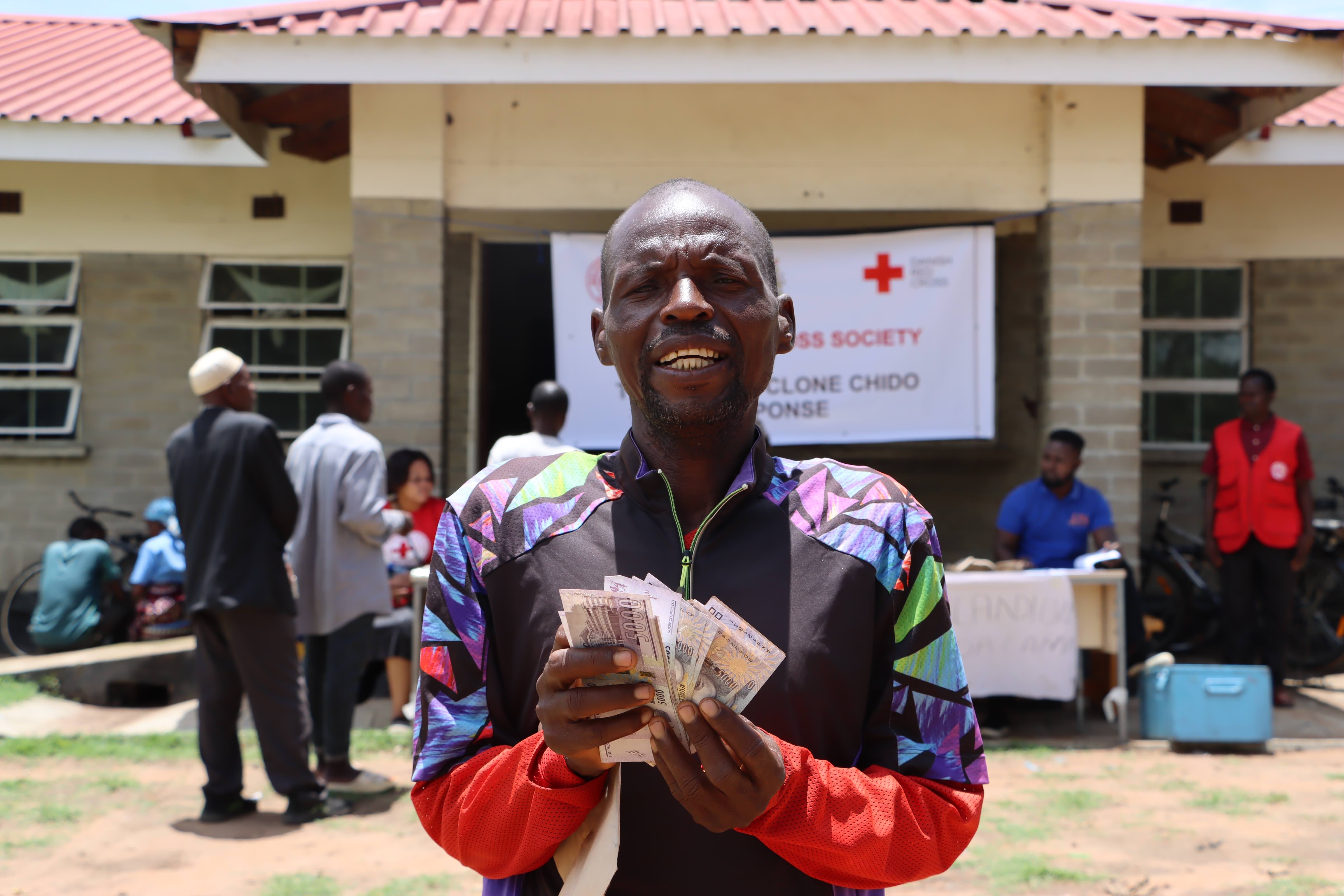 Godfrey Banda, a father of six from Mileme village, smiles with relief after receiving cash support from the Malawi Red Cross Society.