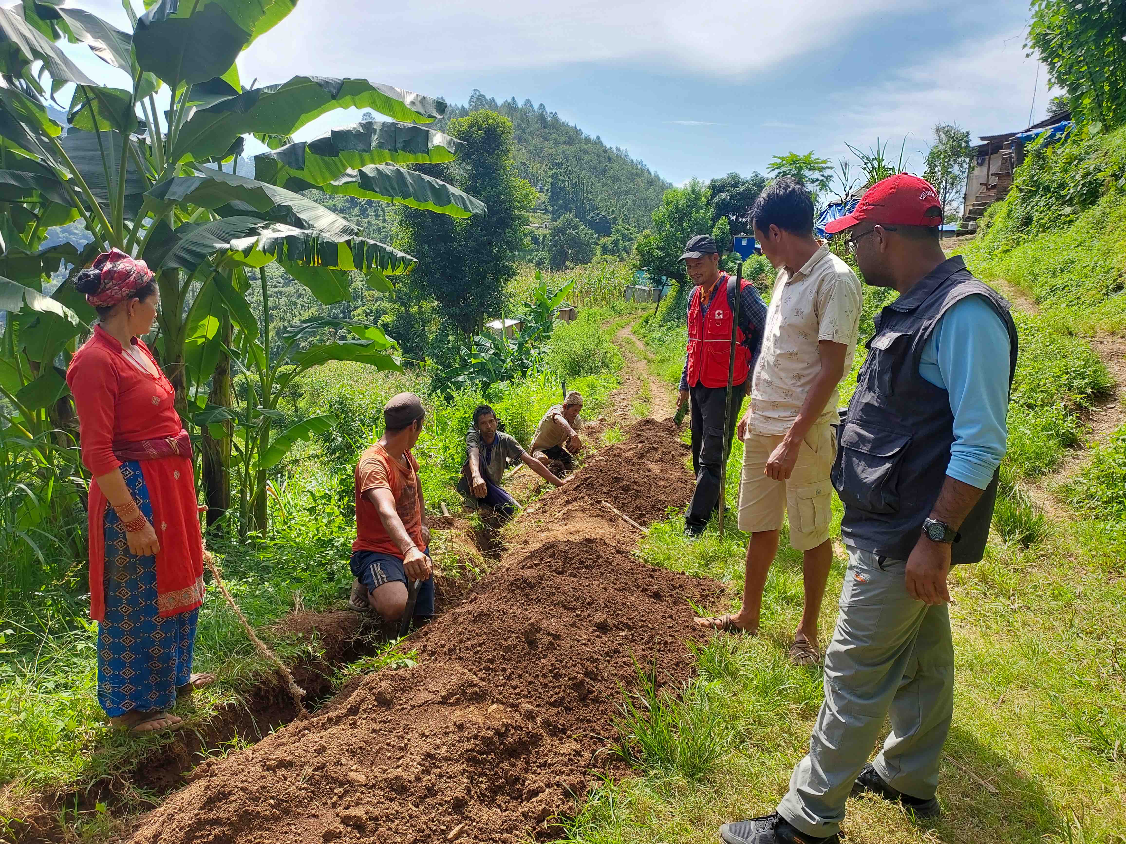 Members of a local water-user committee work alongside a Nepal Red Cross team to lay new water pipes near their remote mountain village.