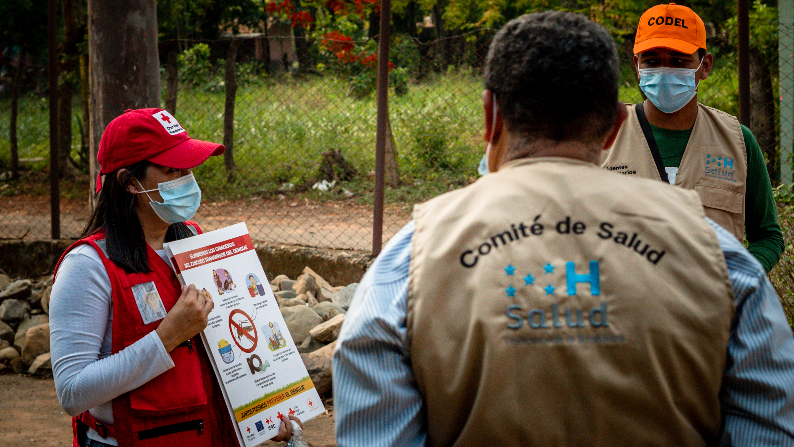 A Honduran Red Cross volunteer shares important messaging around dengue prevention with a local community health committee.