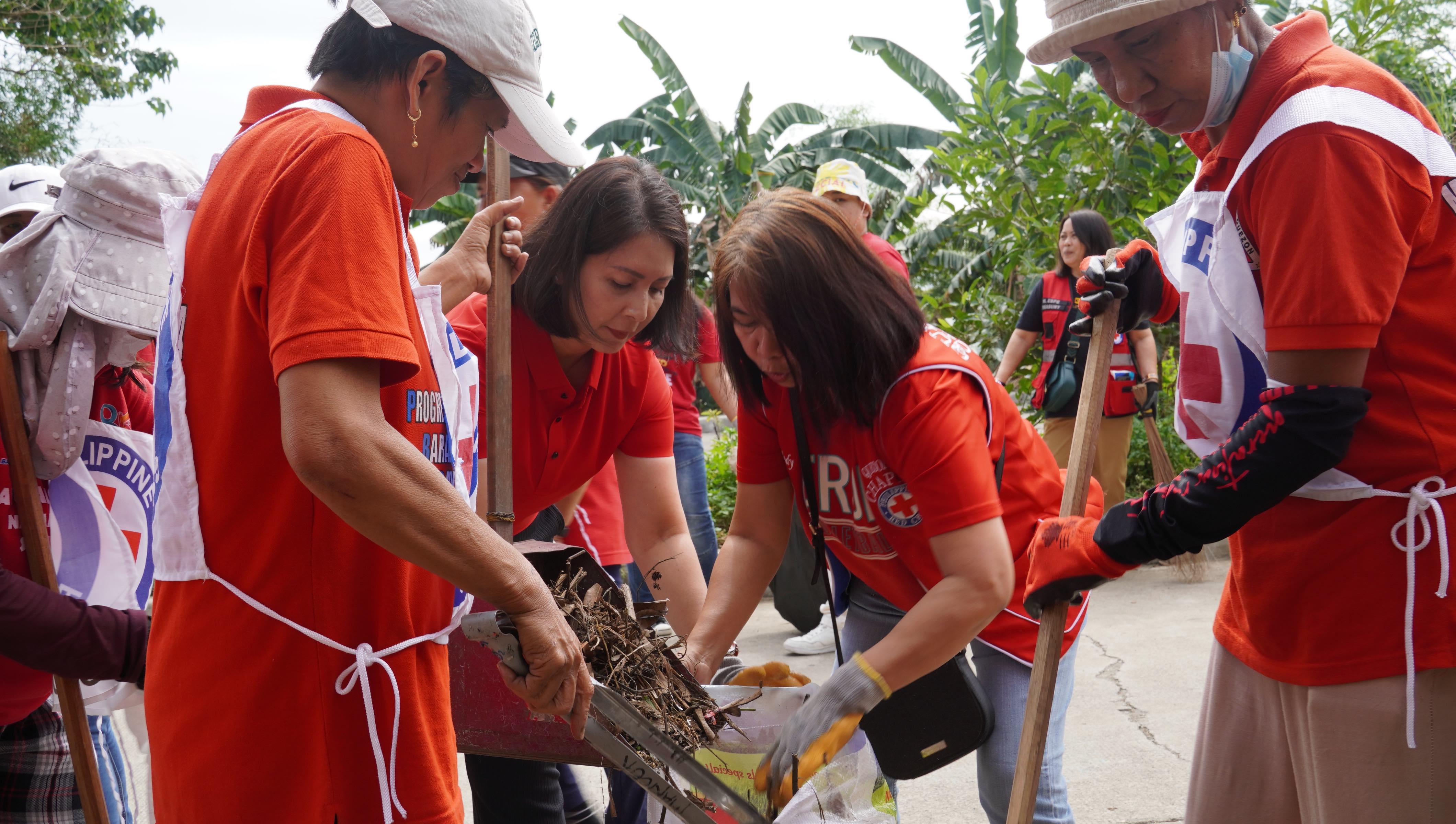 A team of volunteers with the Philippine Red Cross Society take part in a community clean-up operation to reduce the amount of mosquito breeding grounds.