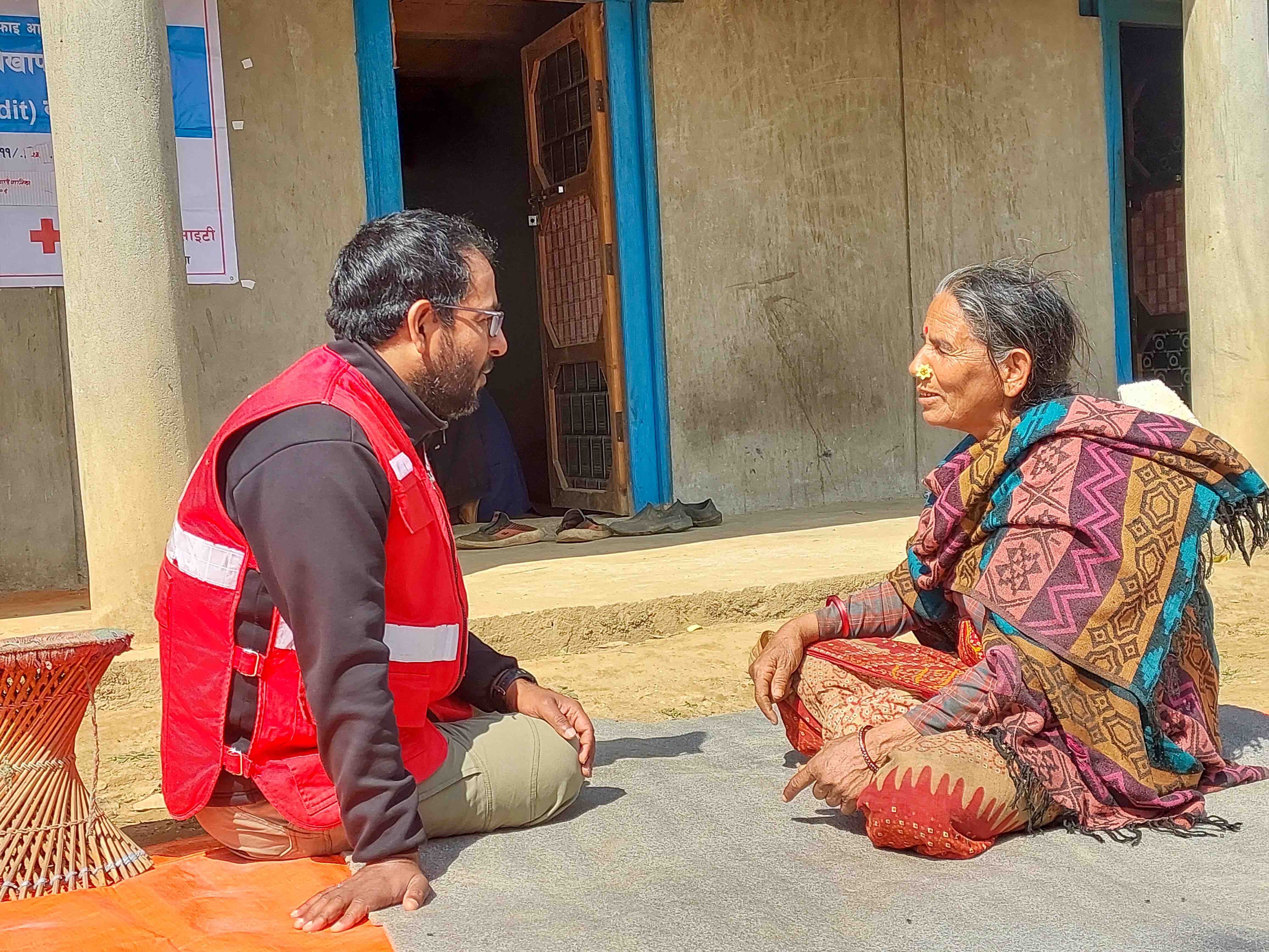 A member of a local water-user committee, Mani Kumari Khattri, from Triveni, in the earthquake-impacted area of Rukum West shares her experience with a Nepal Red Cross staff member.