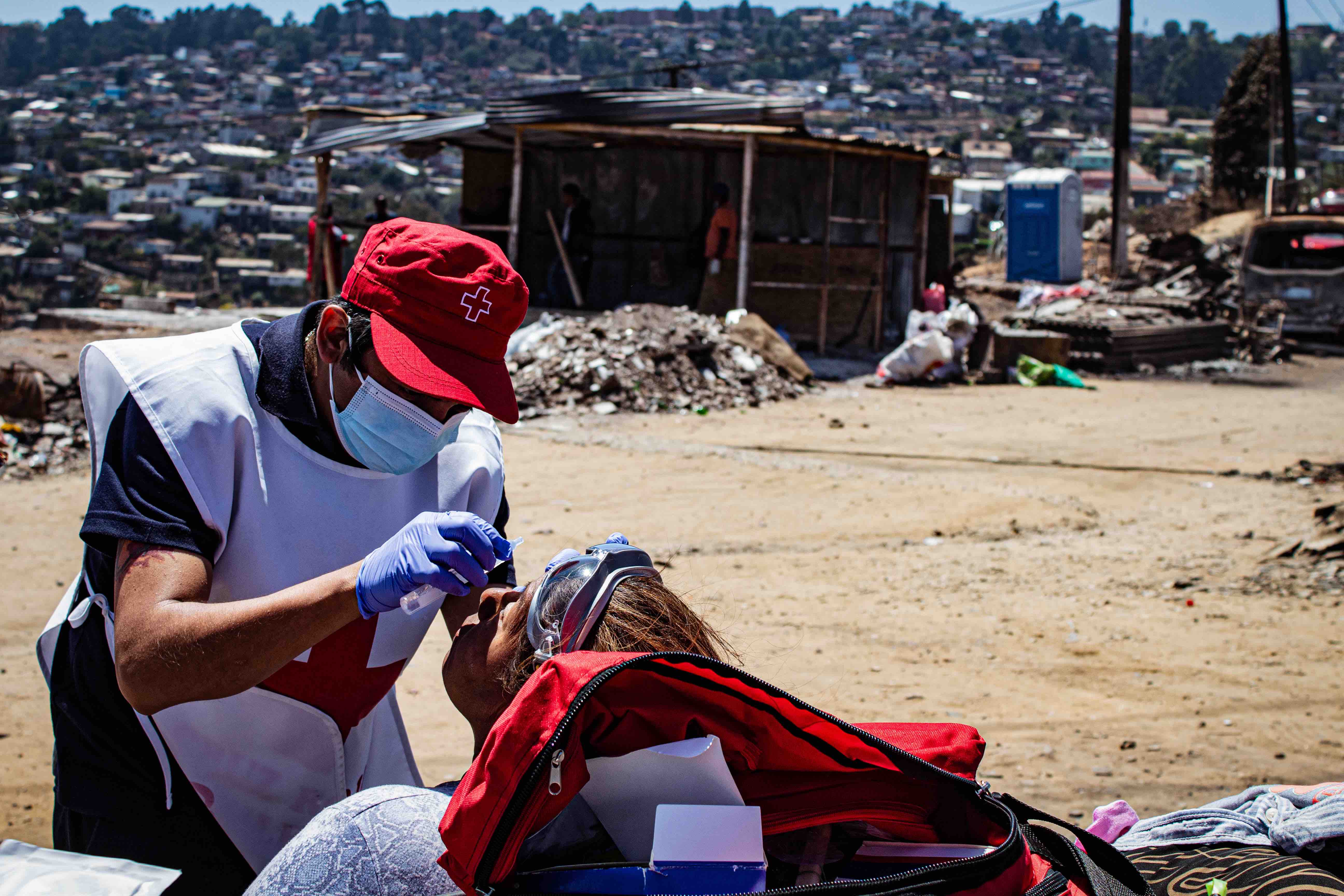A volunteer with the Chilean Red Cross provides eye drops to ease the irritation caused by exposure to smoke. A new, early action protocol developed by the Chilean Red Cross provides residents with first-aid kits and other tools to protect people’s lungs and eyes from smoke and particulate matter.