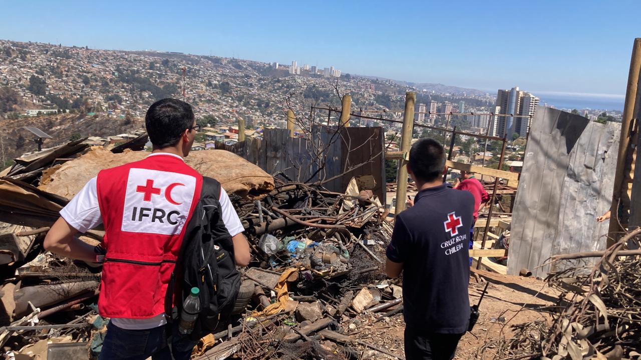 Two staff members from Chilean Red Cross and the IFRC look at damage caused by fires in the municipalities of Viña del Mar and Quilpué. With funds from the IFRC’s Disaster Response Emergency Fund (IFRC-DREF), the Chilean Red Cross helped 10,000 people impacted by the fires over a four-month period. 