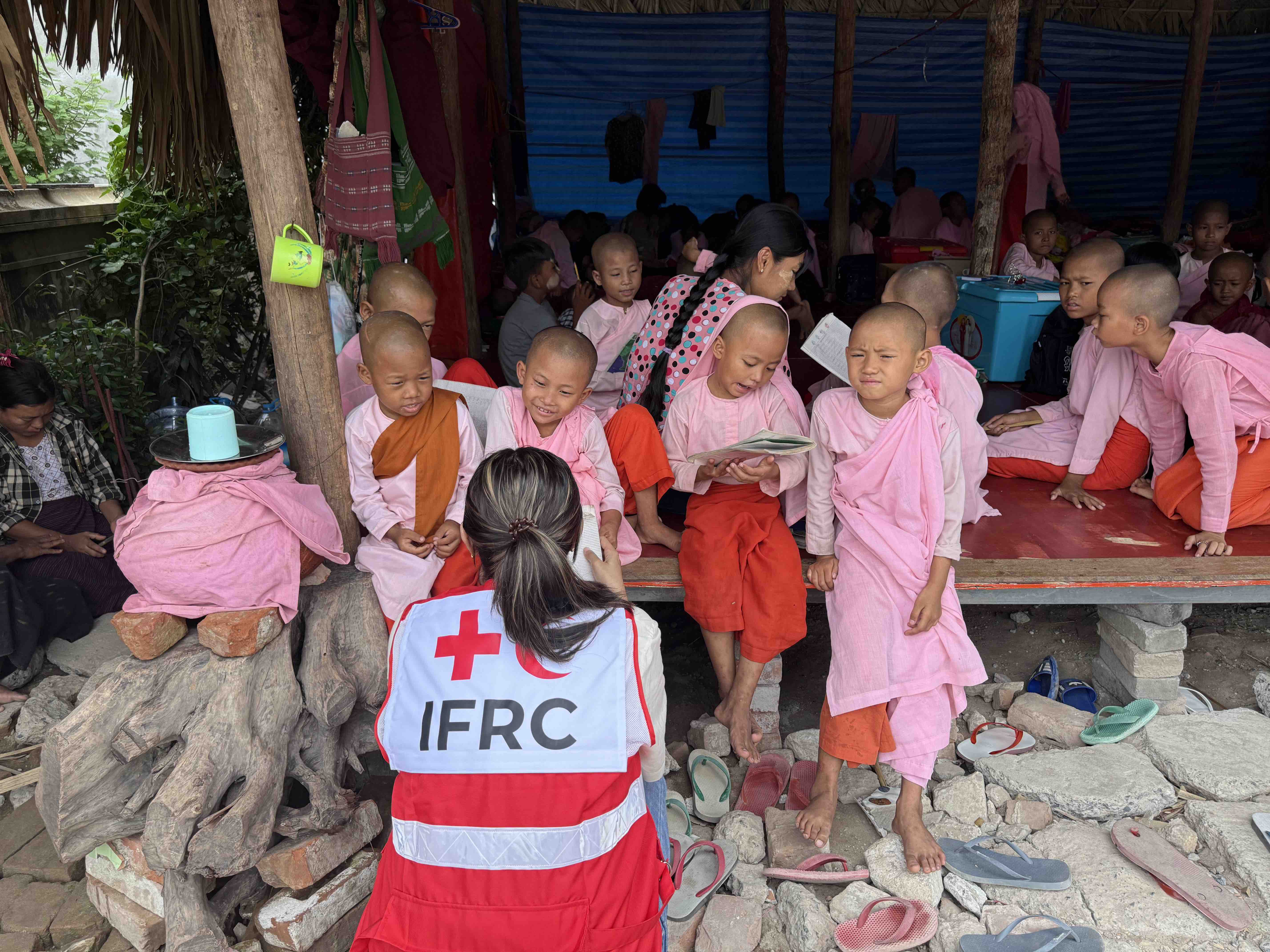 An IFRC communication officer speaks to students at the Yadana Theingi Nun Monastery School, which suffered severe damage and loss of life during the March 2025 earthquake in Myanmar.
