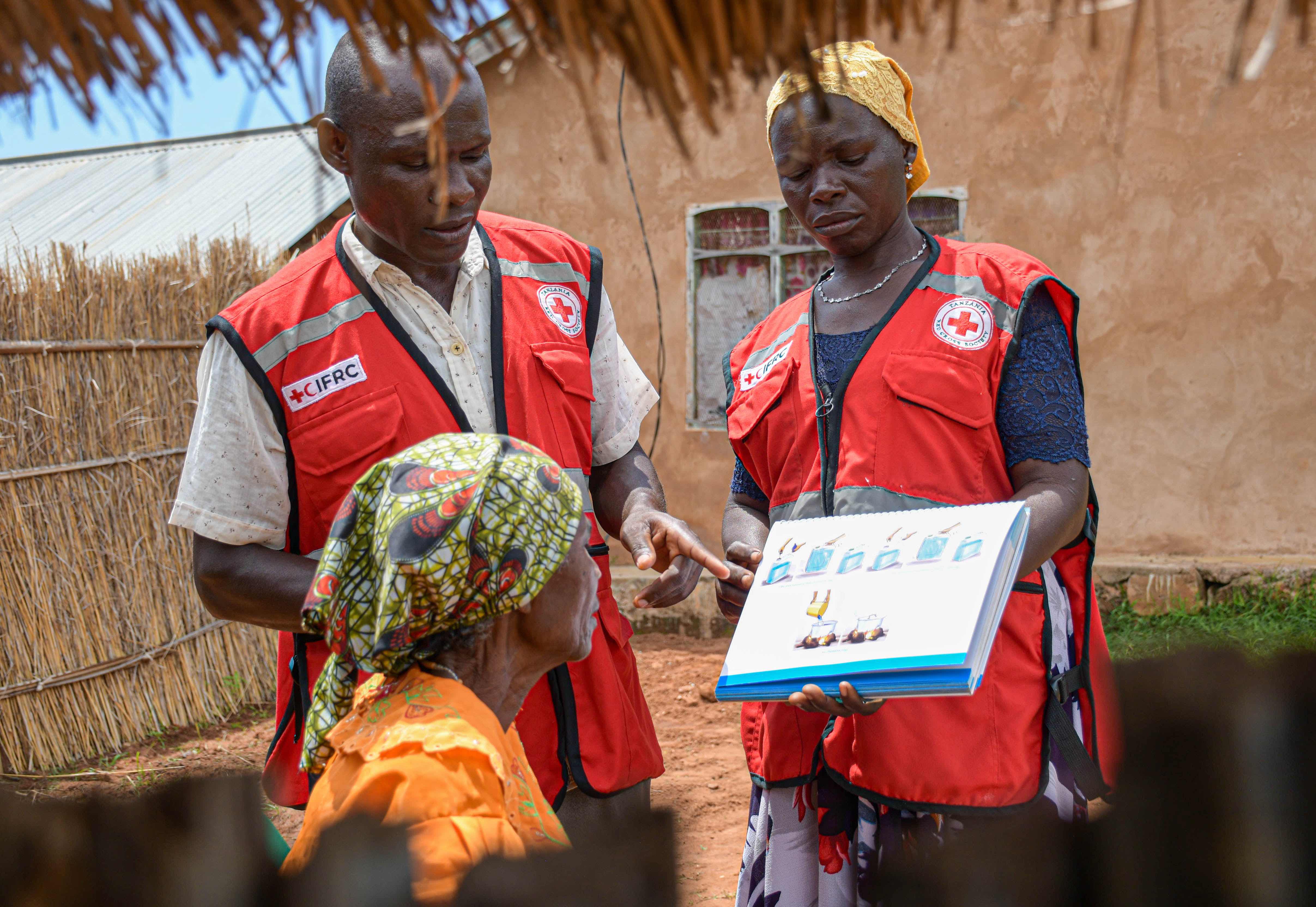 Volunteers for the Tanzania Red Cross go house-to-housee to conduct health education campaigns and distribute essential Cholera prevention supplies as part of their long-time Cholera prevention actions.