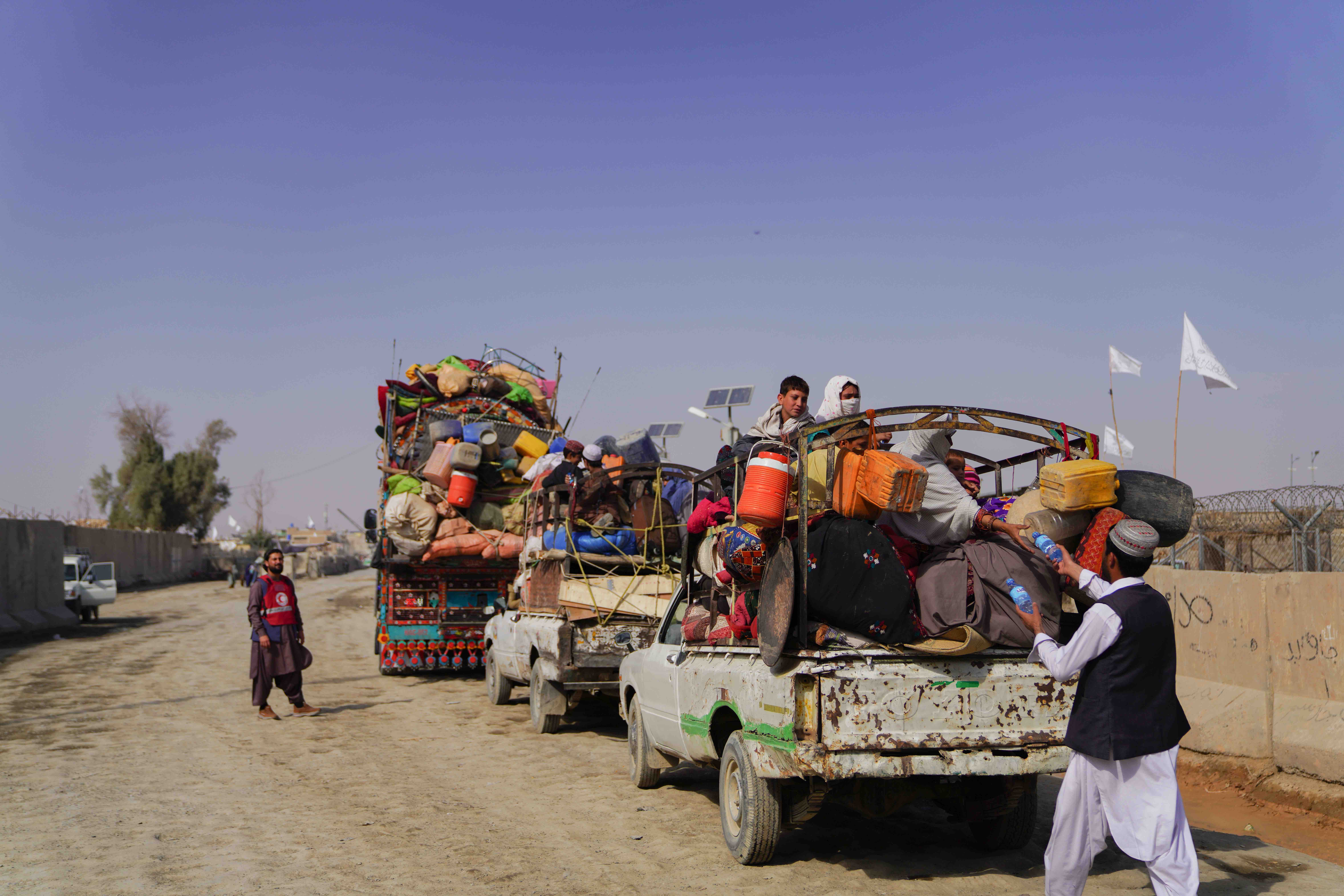 Small trucks carrying sometimes several families and their belongings arrive in the Afghan town of Nangarhar. 