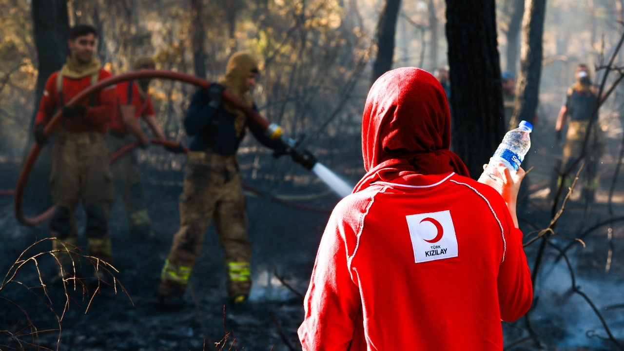 Turkish Red Crescent volunteers deliver water and food to emergency responders battling fires in Izmir.