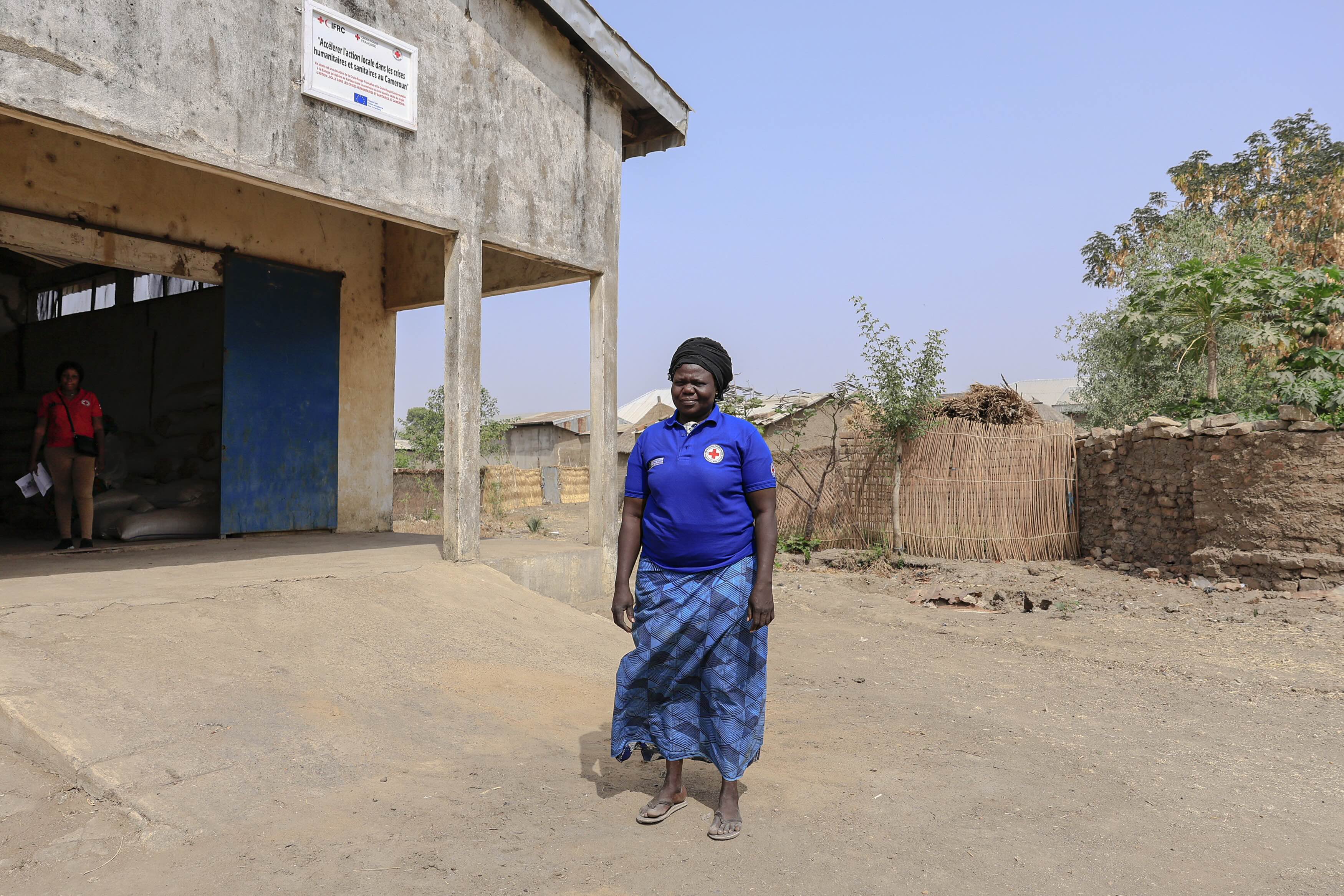 Ahmadou Sergeline, a mother of nine, farmer, and president of the Soubota women’s cereal bank in Kartoua, standing in front of the storage building.