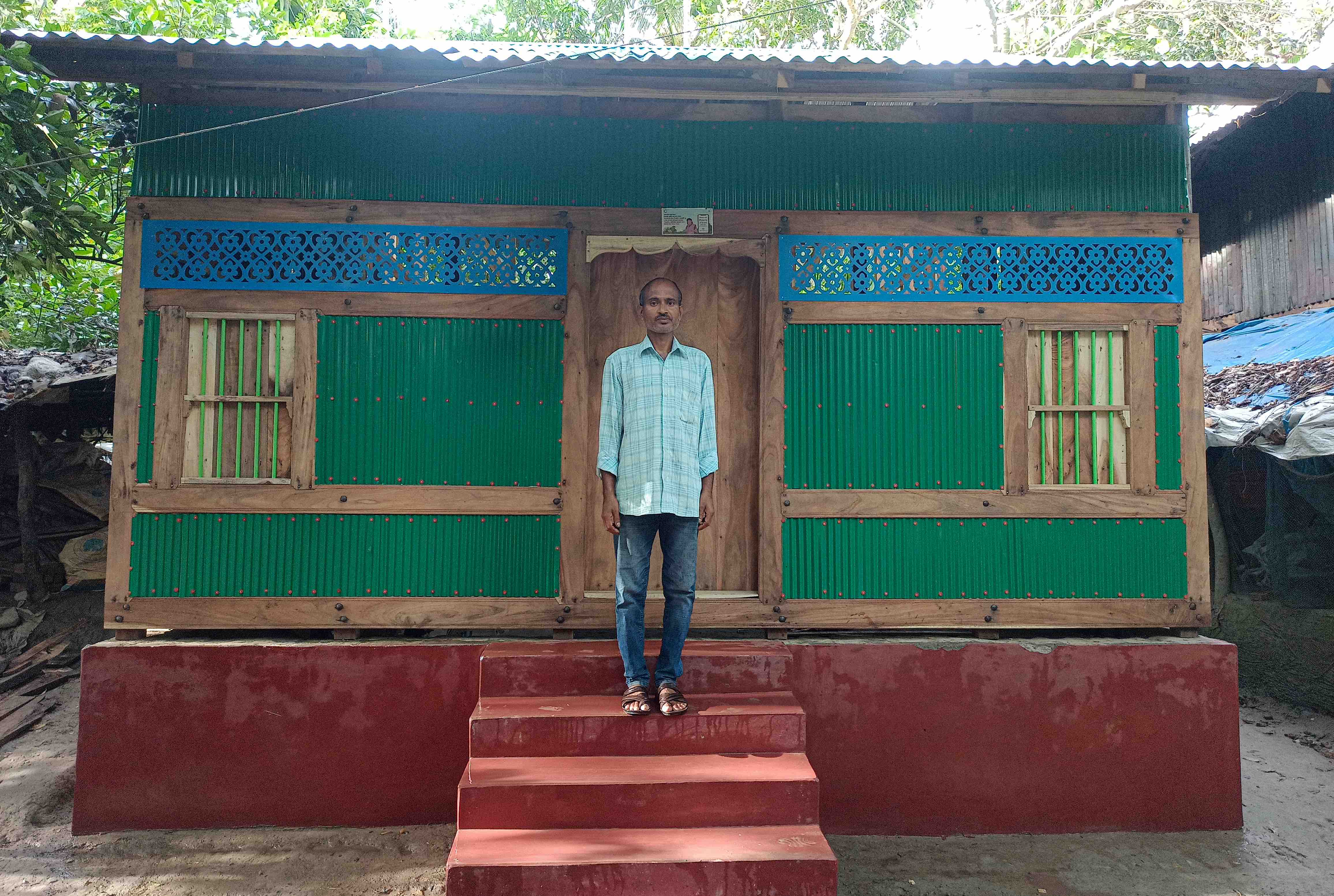 Private tutor Shanjeet stands in front of the new shelter he was able to construct with help from the IFRC, its membership, and the Bangladesh Red Crescent Society.