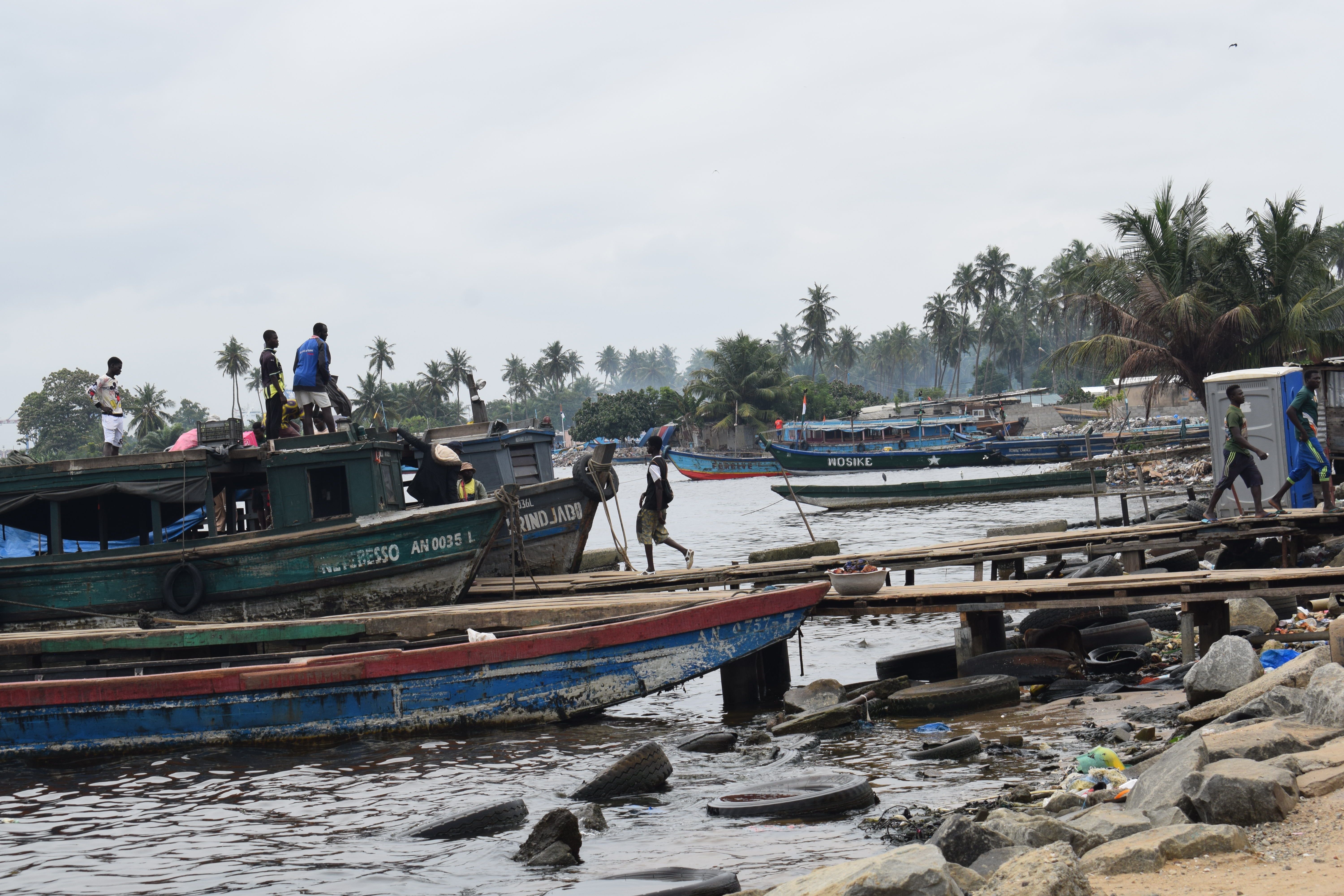 Les gens montent à bord d’un petit bateau à Vridi Ako, un village de plus de 19 000 habitants où les gens font souvent des allers-retours entre les pays de l’Afrique de l'Ouest, notamment le Ghana, le Liberia, le Mali, la Sierra Leone, la Guinée et le Sénégal. 