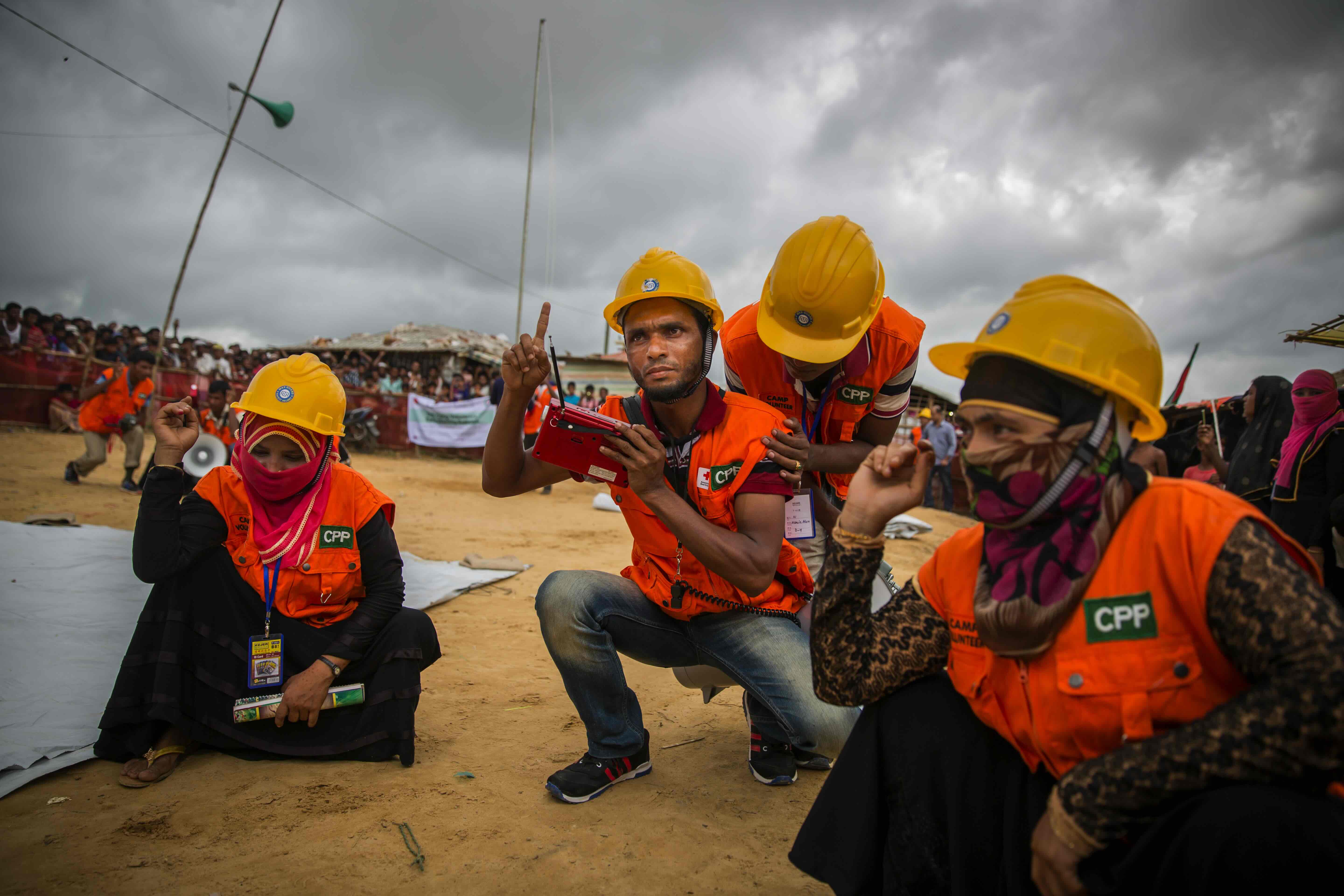 En los extensos campamentos de personas refugiadas de Cox's Bazar, en Bangladesh, voluntarios como estos, pertenecientes a la comunidad del campamento, se encargan de preparar y alertar a la población ante la llegada de tormentas y otras posibles emergencias.