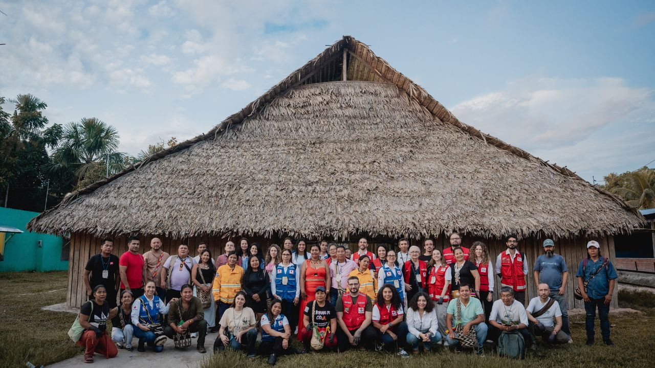 Participantes del primer diálogo de sistemas conocimiento de la Alianza de la Cruz Roja por la Amazonía, posan en las afueras de la maloka -una casa comunal indígena- de San Sebastián.