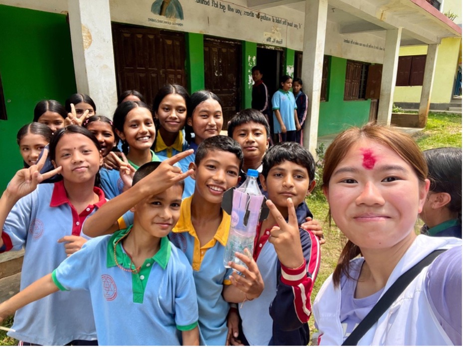 Tam Wai Yan Dorothy takes a selfie photo with school children she met during a nine-day programme organized by the Hong Kong Red Cross University Club. 