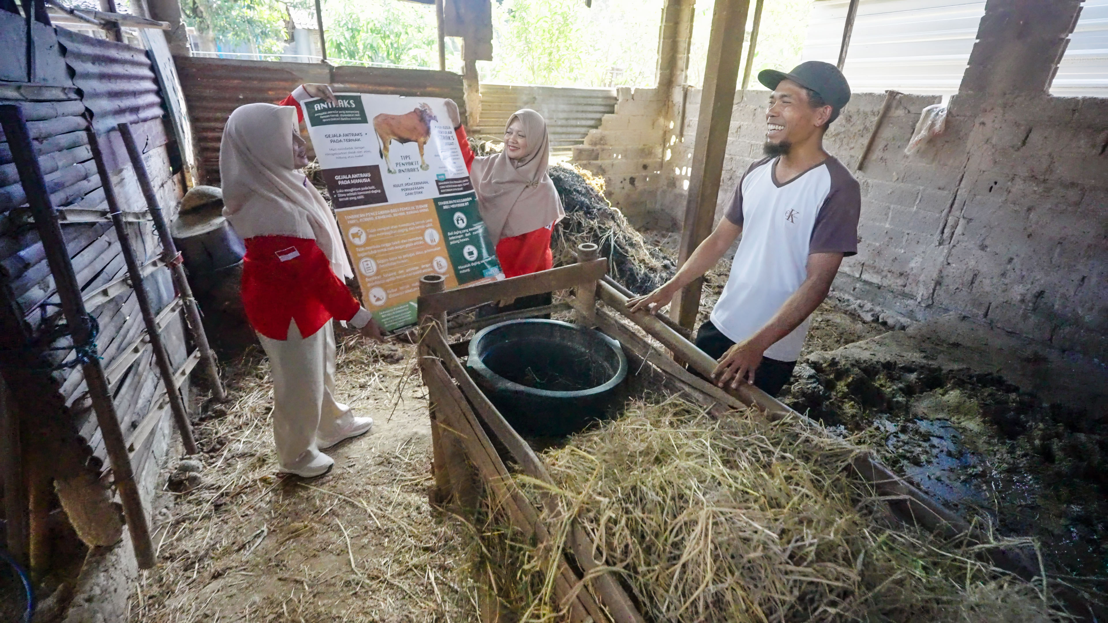 Bu Im and a fellow volunteer visit a farmer in his home to remind him of anthrax signs to look out for in his animals and how he can report anything unusual so authorities can respond quickly in case of an outbreak.__