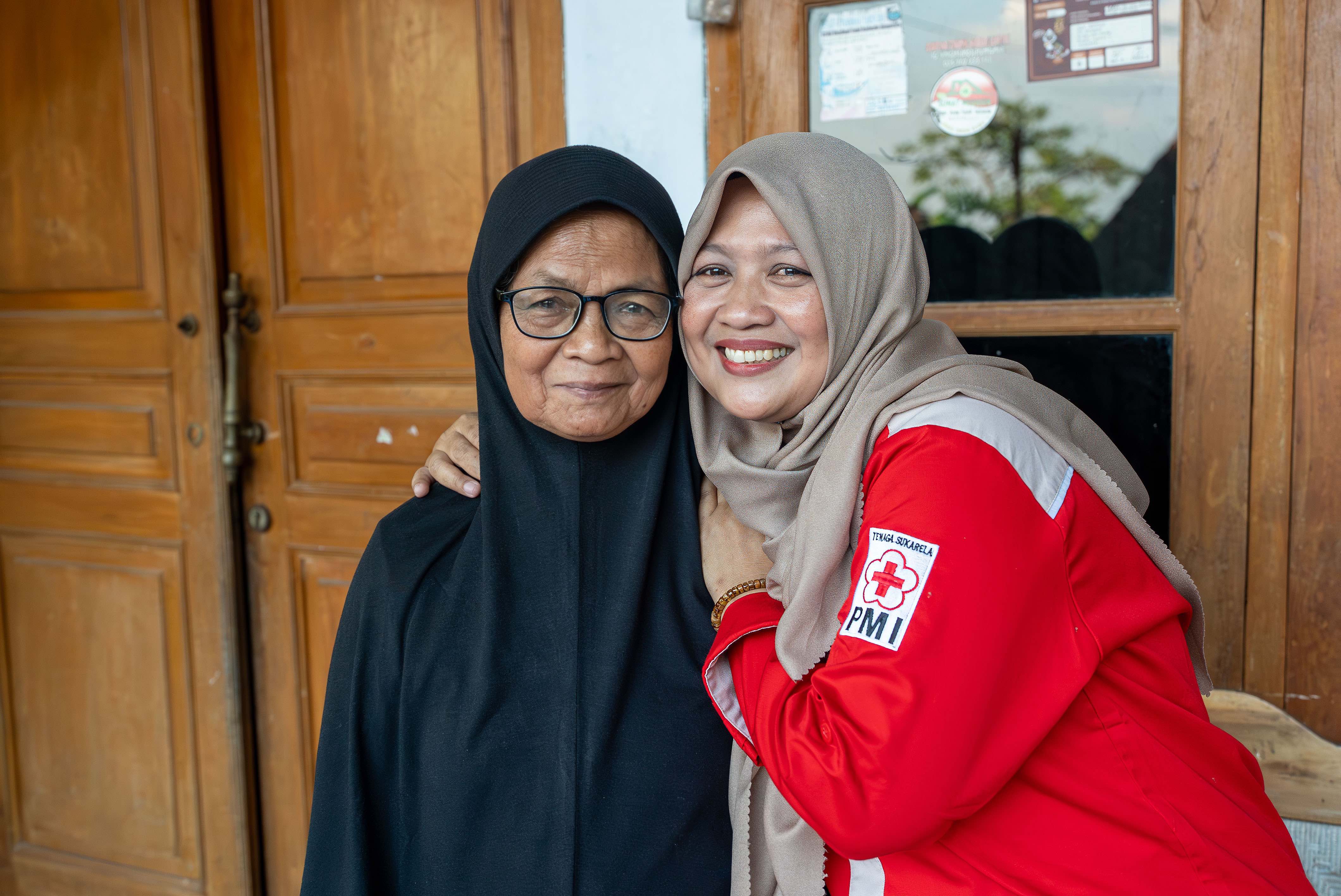 Indonesian Red Cross volunteer, Siti - also known as Bu Im - hugs her mother, Suharti, who recovered from contracting anthrax during an outbreak in their village back in 2011.