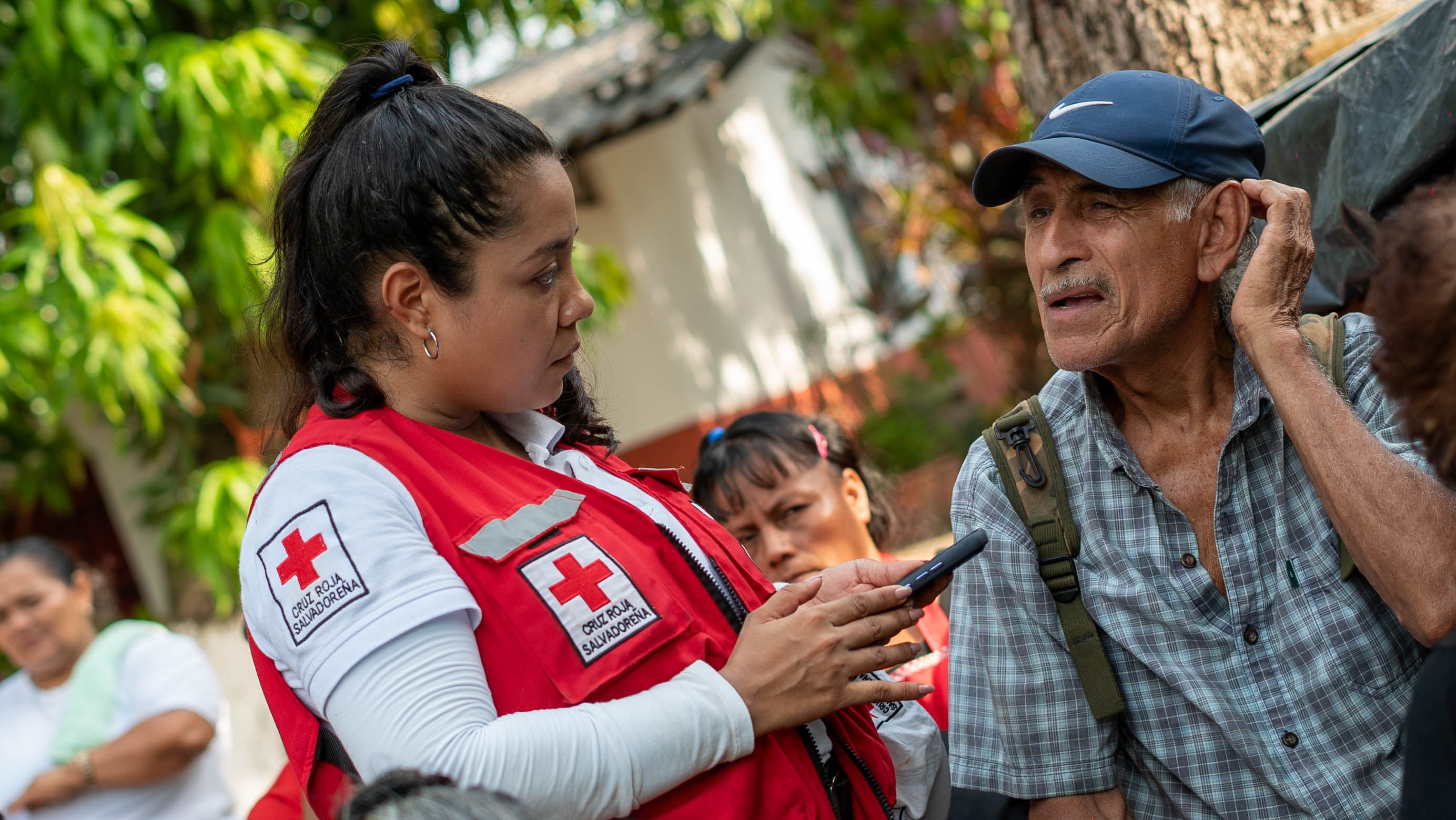 A volunteer for the Salvadorean Red Cross speaks with a local resident as part of community trainings on how to prepare for and reduce the impact of disasters, from storms and floods to earthquakes.