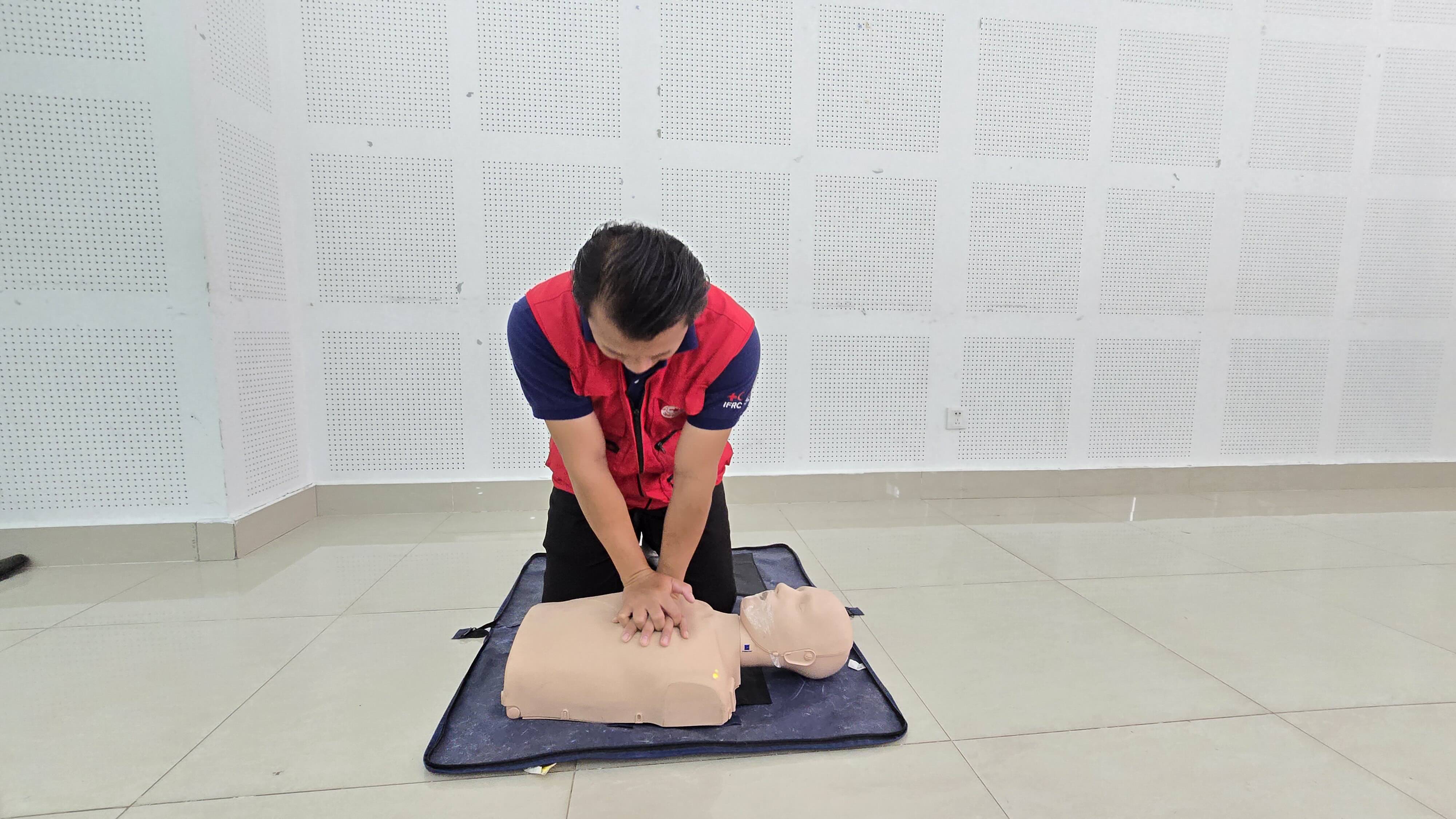 At a recent workshop, Kaithong Sesavath, First Aid trainer and Deputy Head of the LRC Basic Health Department, demonstrates the key steps of saving lives following a heart attack (calling for help, checking safety and responsiveness, performing chest compressions, and giving rescue breaths).