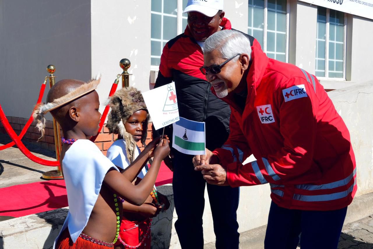 A young boy greets IFRC Secretary General Jagan Chapagain during a welcoming ceremony in Lesotho.