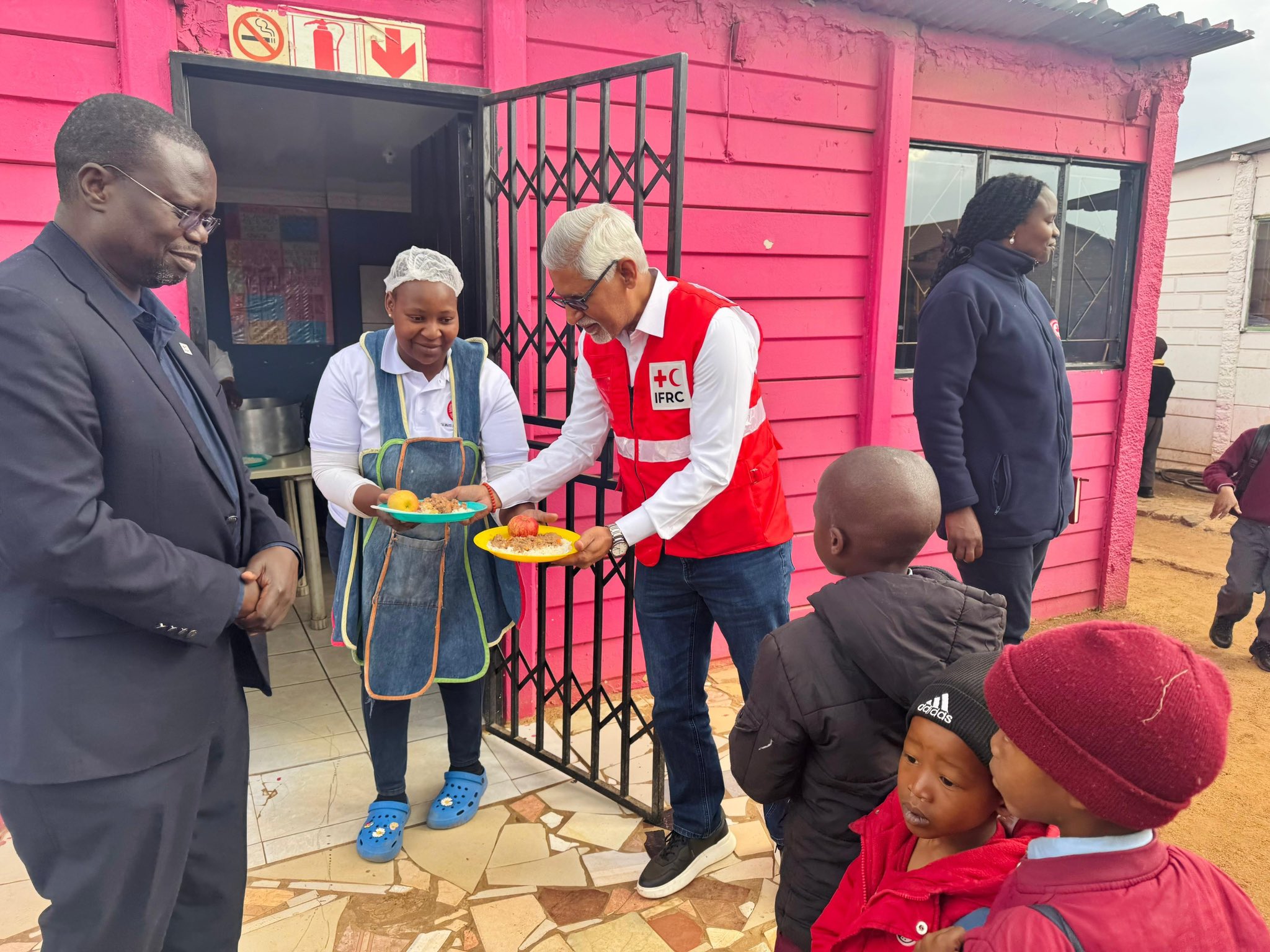 Secretary General supporting the volunteers of the South African Red Cross Society as they provide local children with meals.